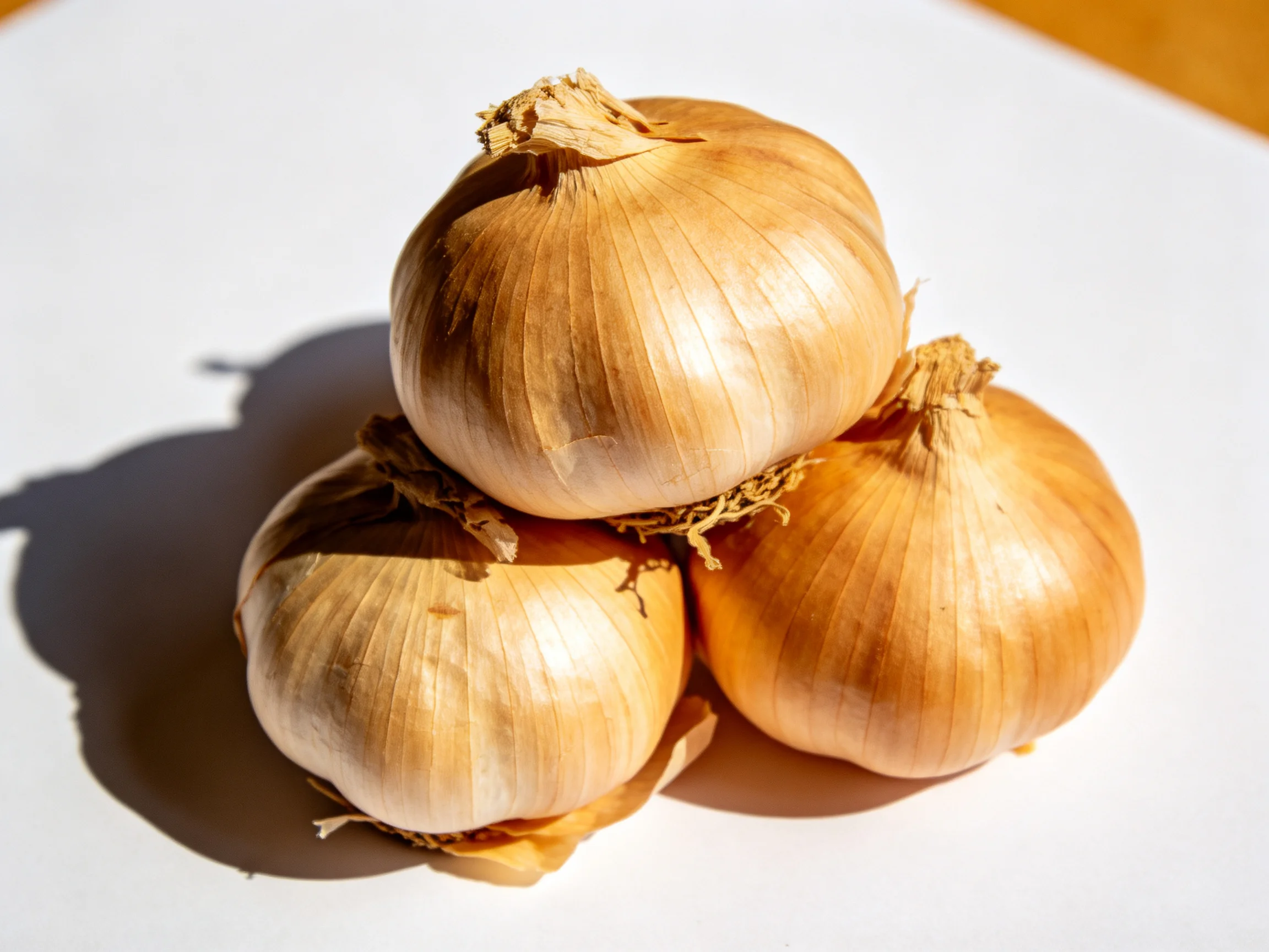 Three golden-brown onions stacked in a pyramid formation