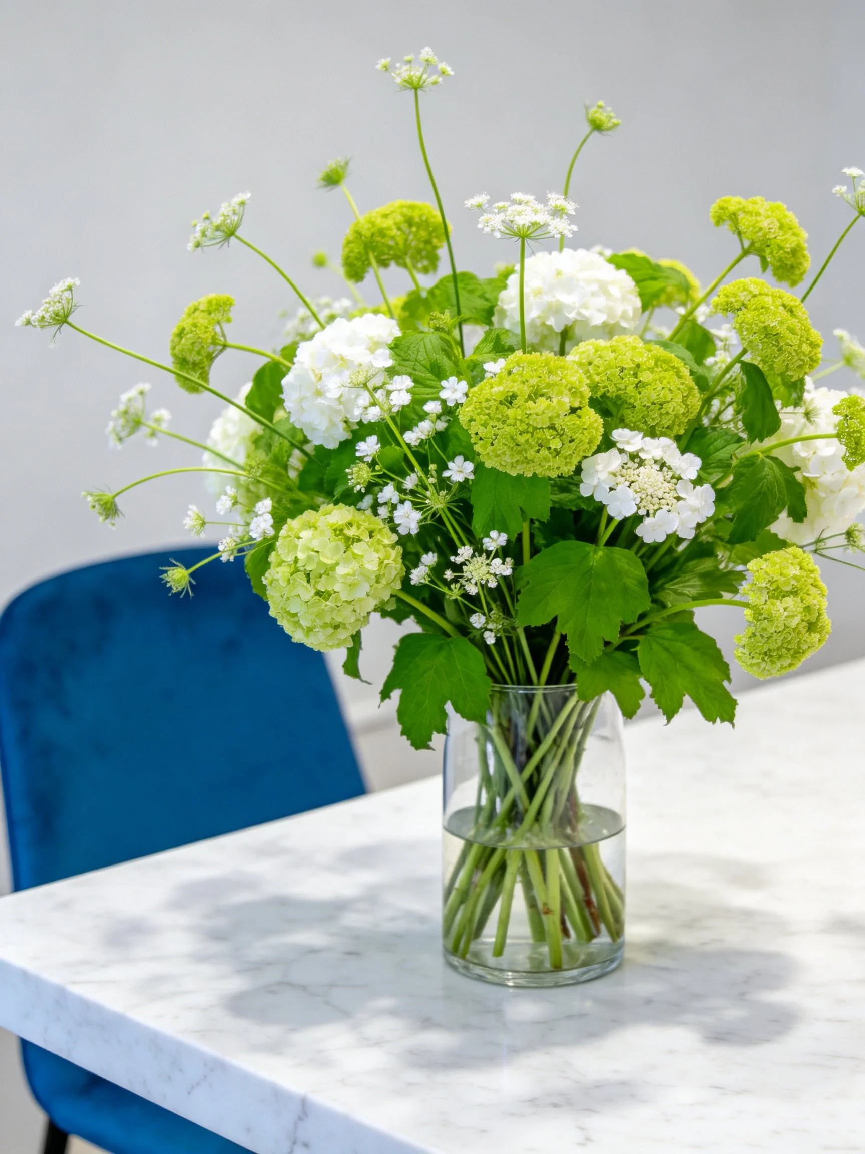 Fresh floral arrangement with green and white blooms in glass vase