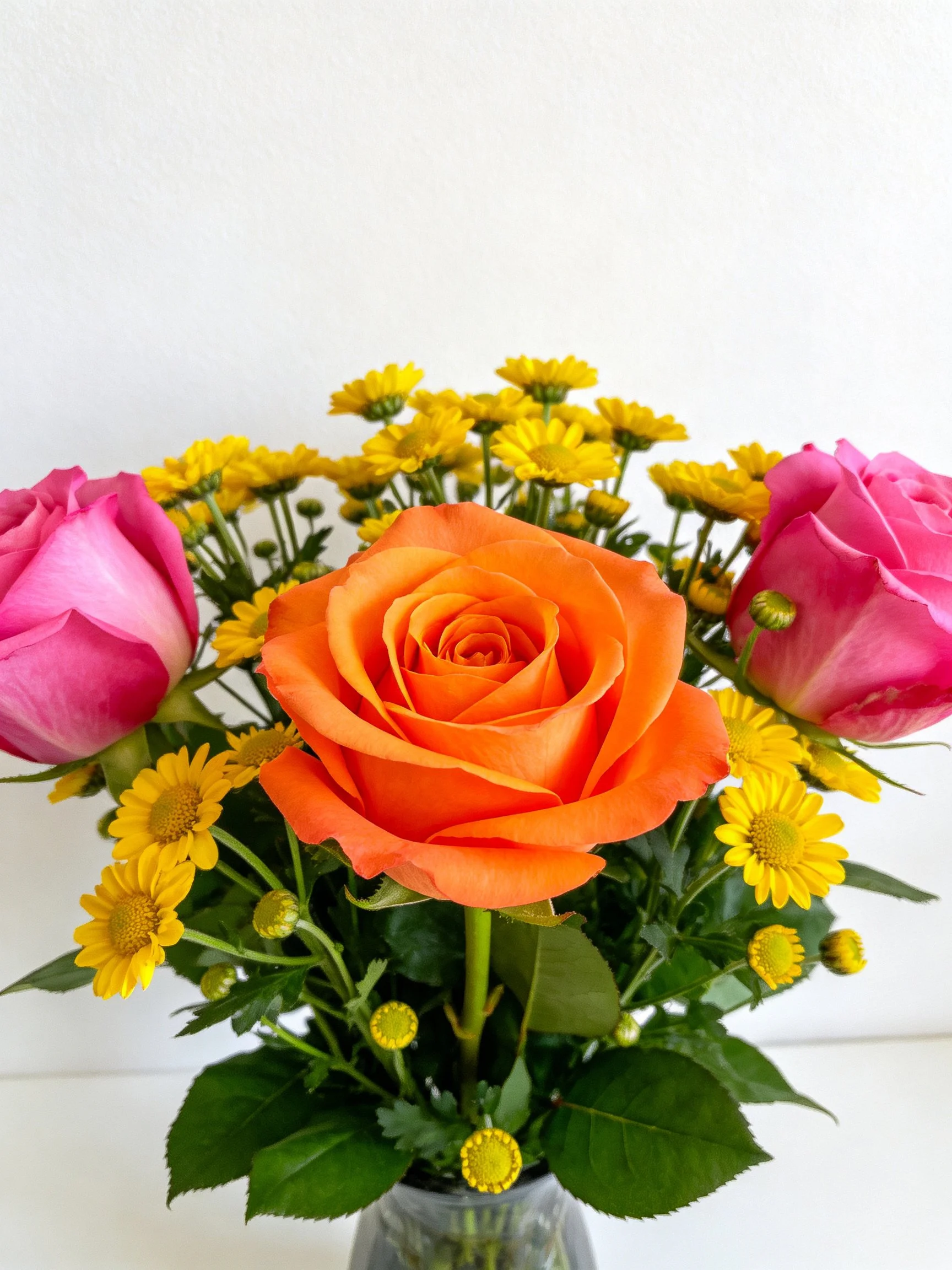 Vibrant bouquet featuring orange, pink roses, and yellow flowers