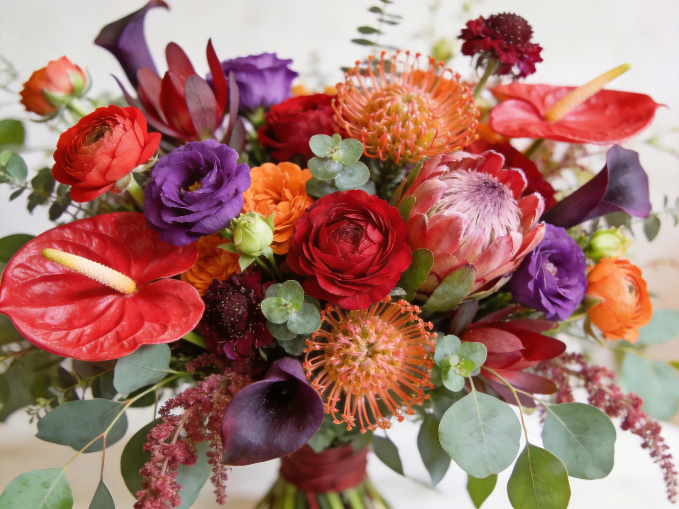 A vibrant floral arrangement with red, purple, and orange blooms