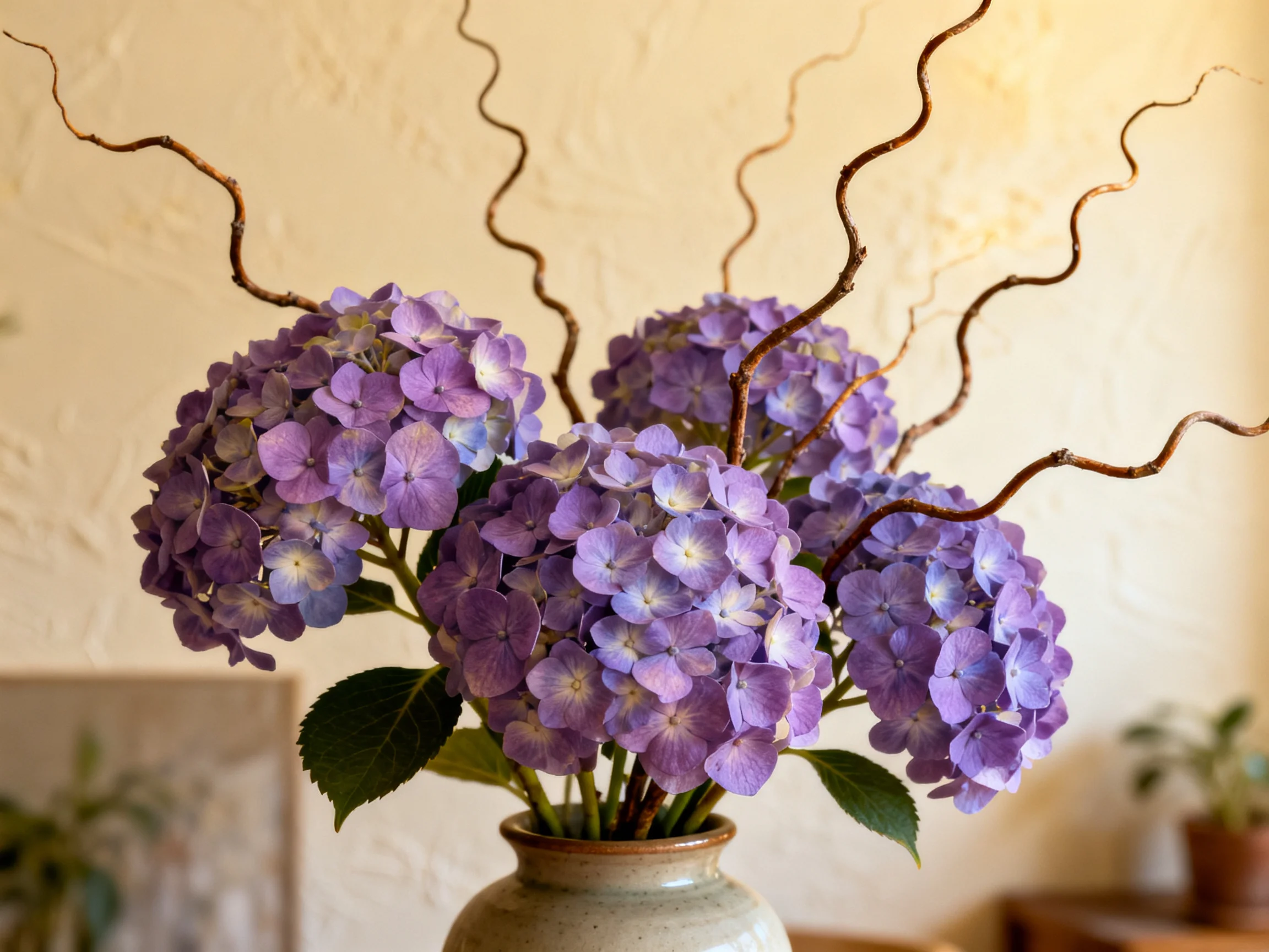 Purple hydrangea bouquet with twisted branches in a ceramic vase