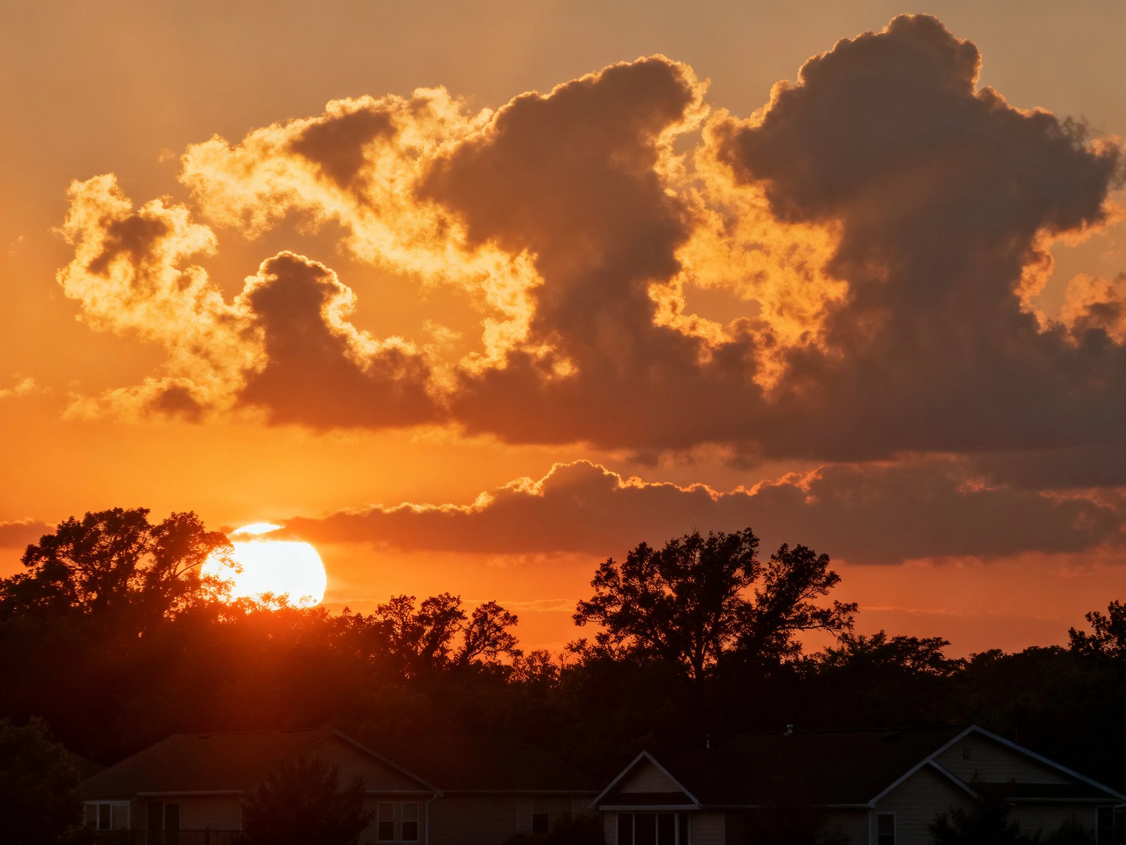 A Golden Sunset with Dramatic Clouds Over Residential Homes