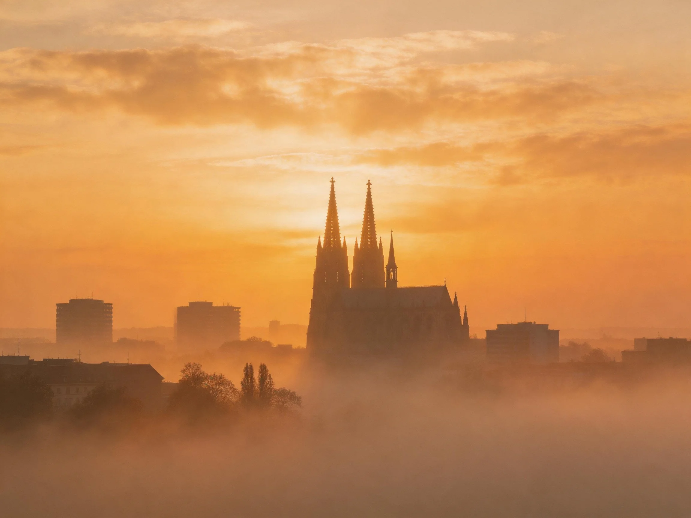 A Mist-Shrouded City at Sunrise with a Gothic Cathedral