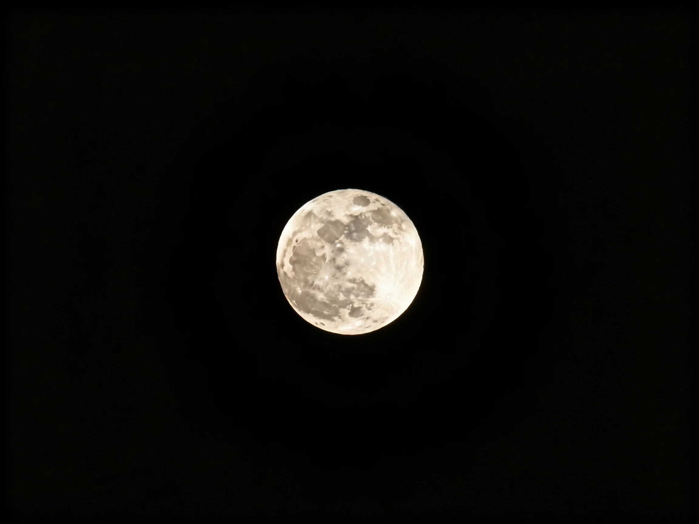 A luminous full moon set against a pitch-black night sky