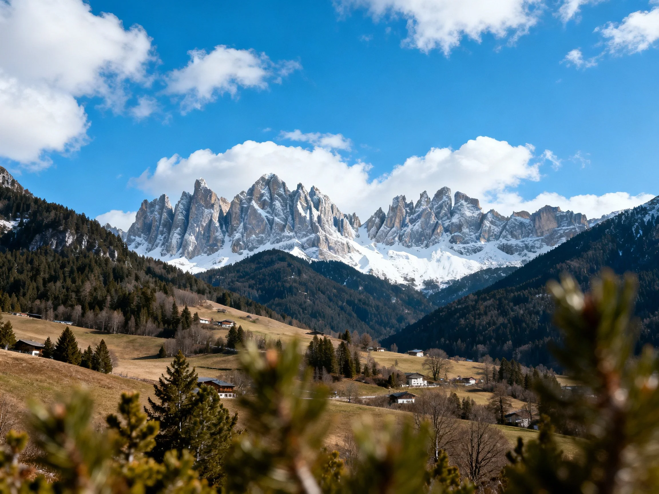 A majestic mountain range with snow-capped peaks and forested valleys