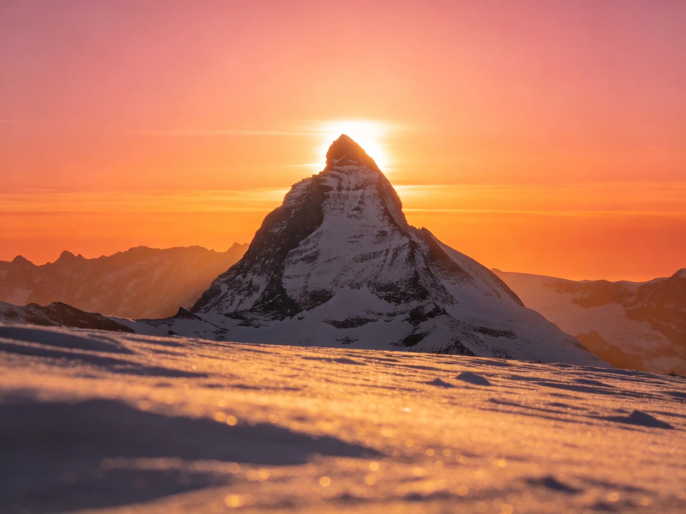 A majestic snow-capped mountain peak at golden sunset hour