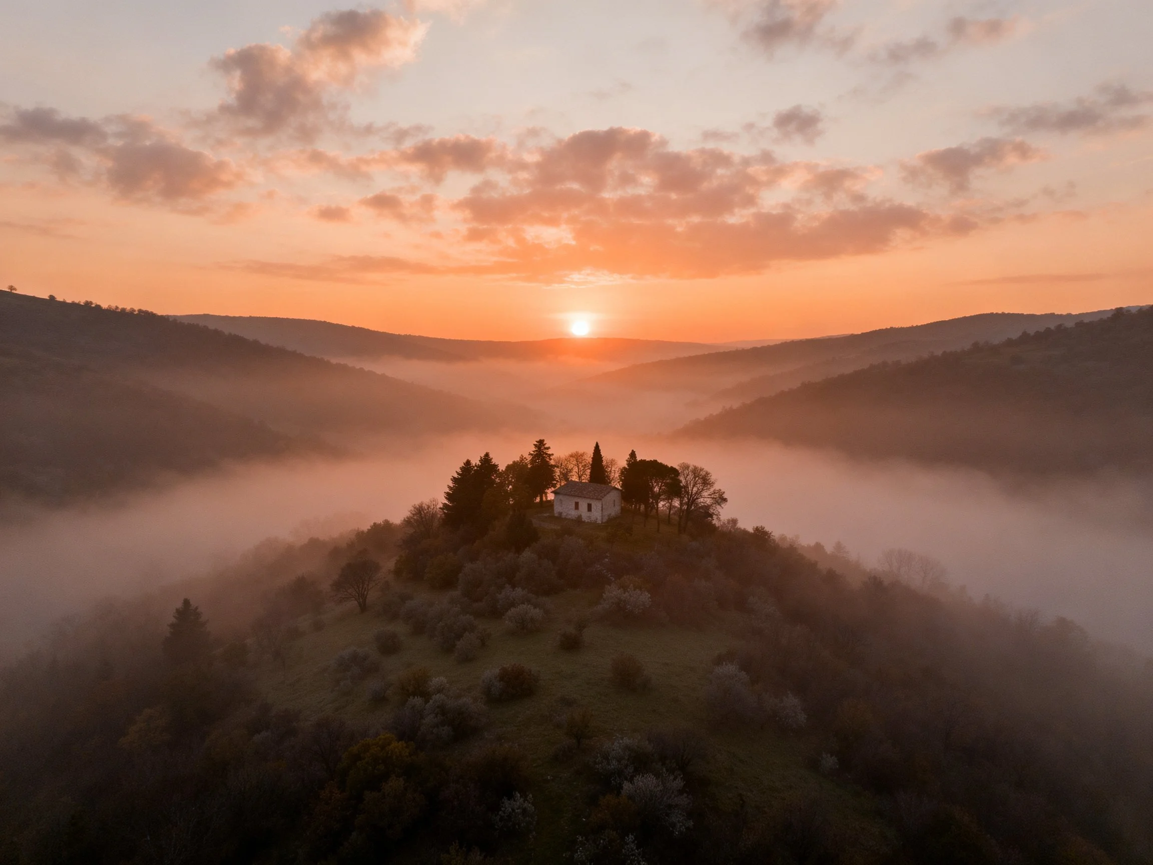 A solitary house atop a misty hill at sunrise