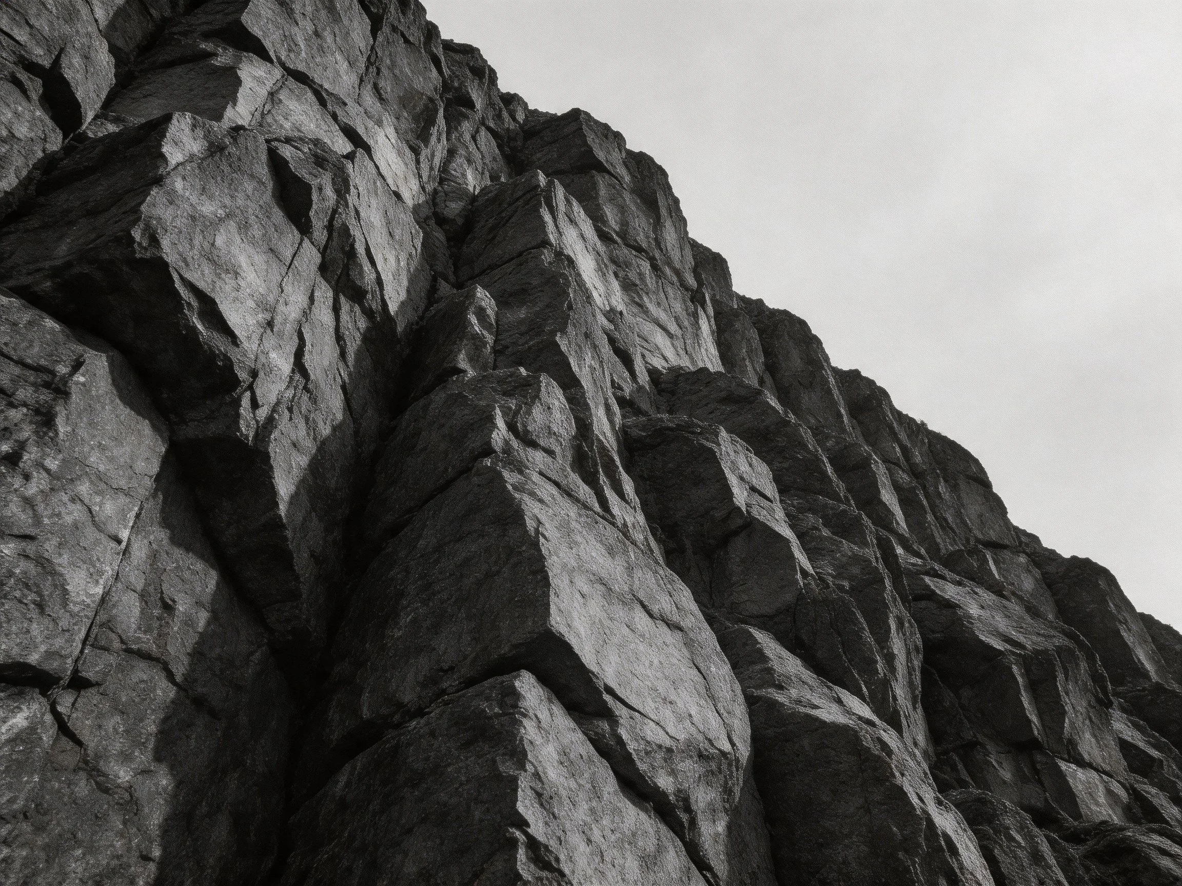A stark black - and - white view of a rugged, jagged rock formation