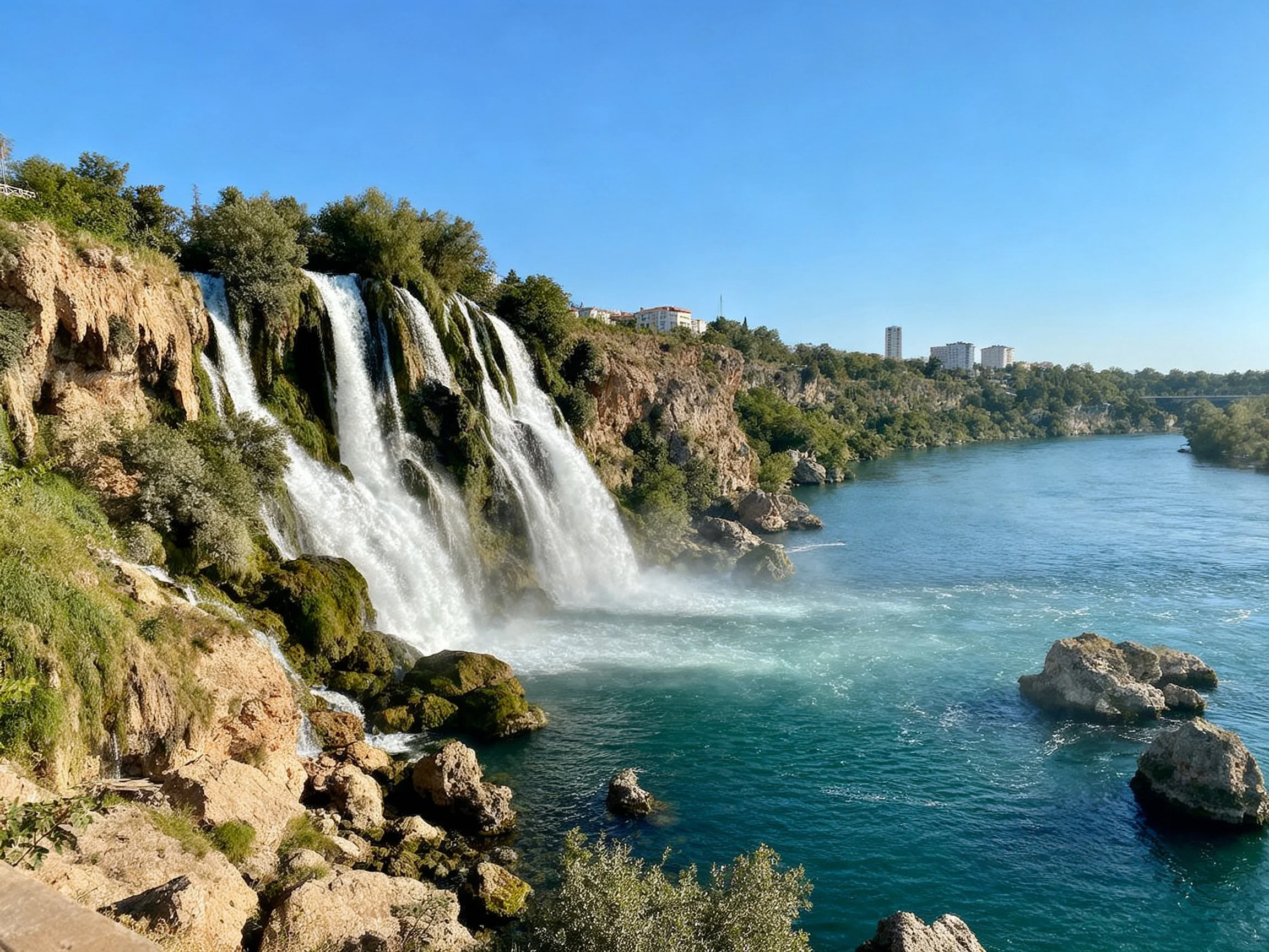 A tall waterfall cascades over rocky cliffs into turquoise waters