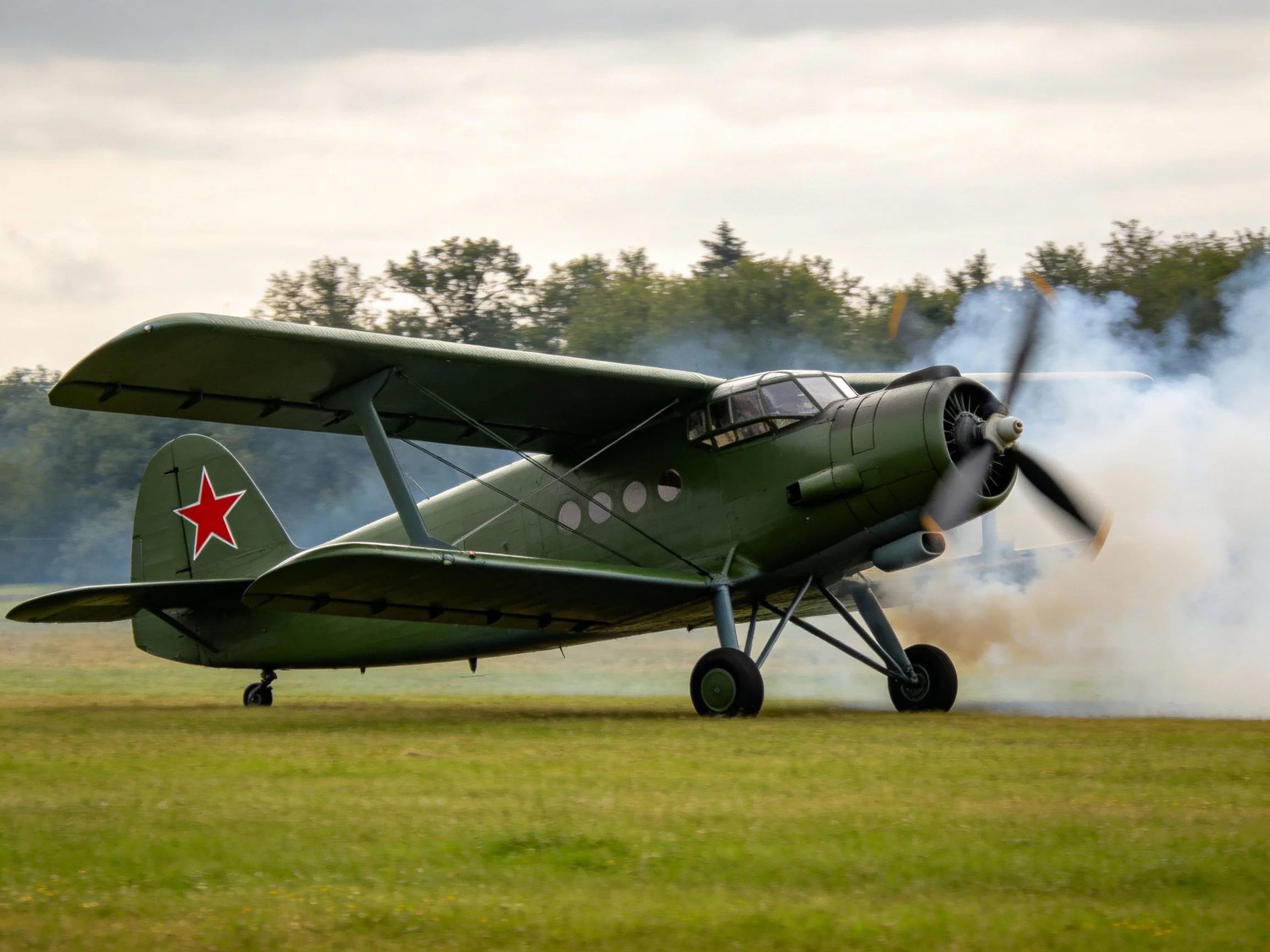 A vintage olive-green biplane with red star emblem