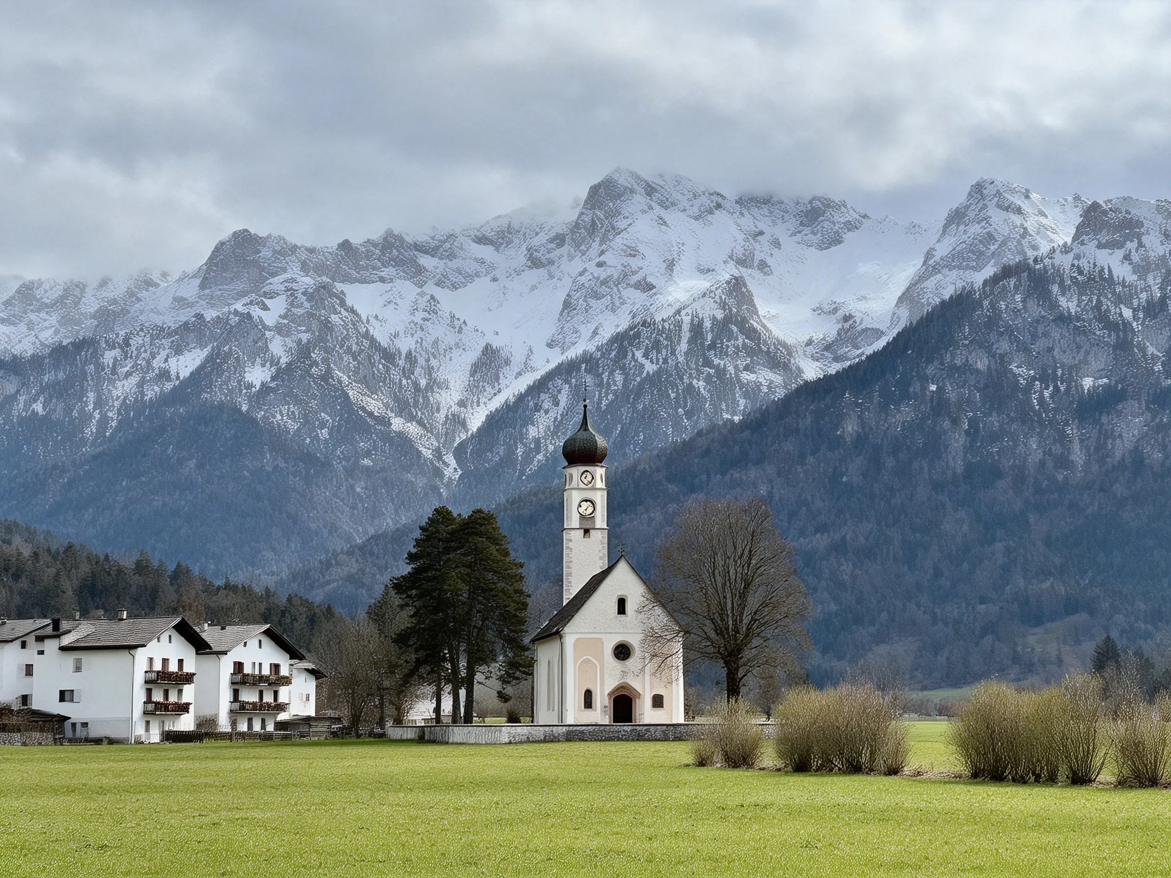 A white church with clock tower near snow-capped mountains