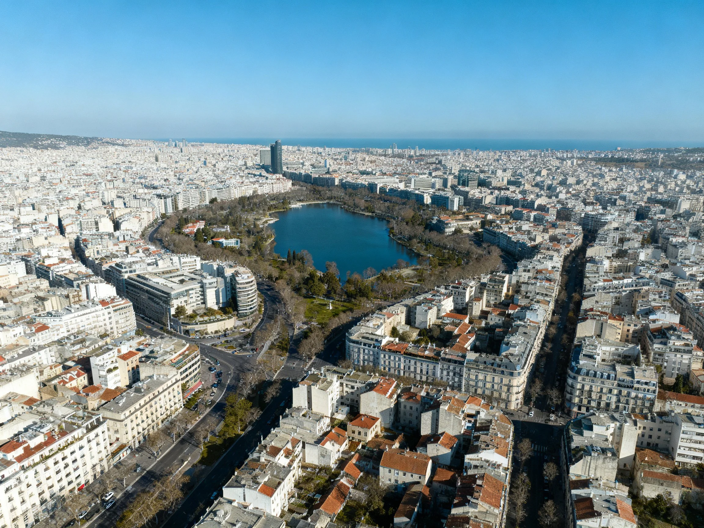 Aerial view of a city with central circular lake and dense urban architecture