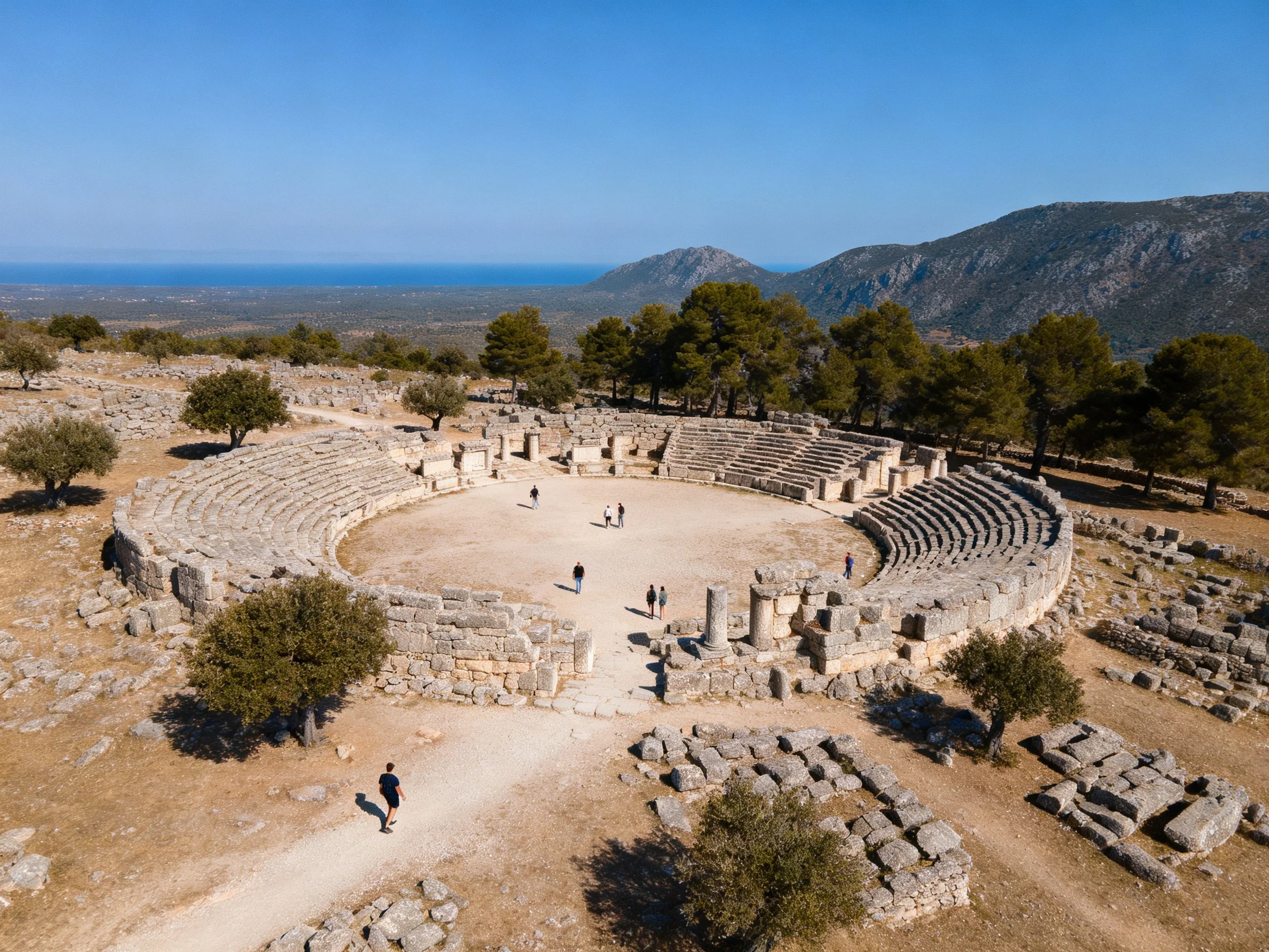 Ancient stone amphitheater ruins with mountainous backdrop