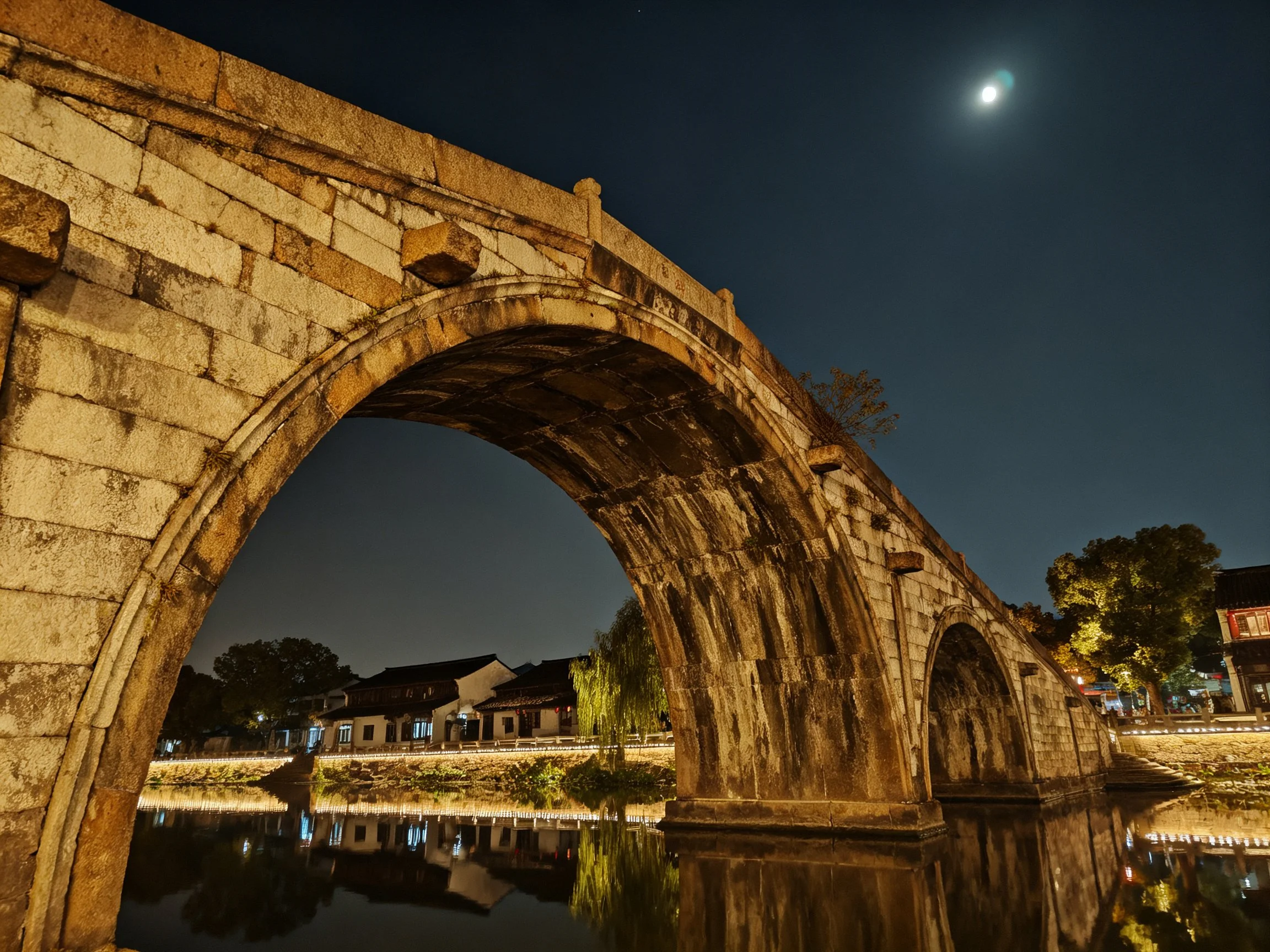 Ancient stone arch bridge spans tranquil waterway under moonlit sky