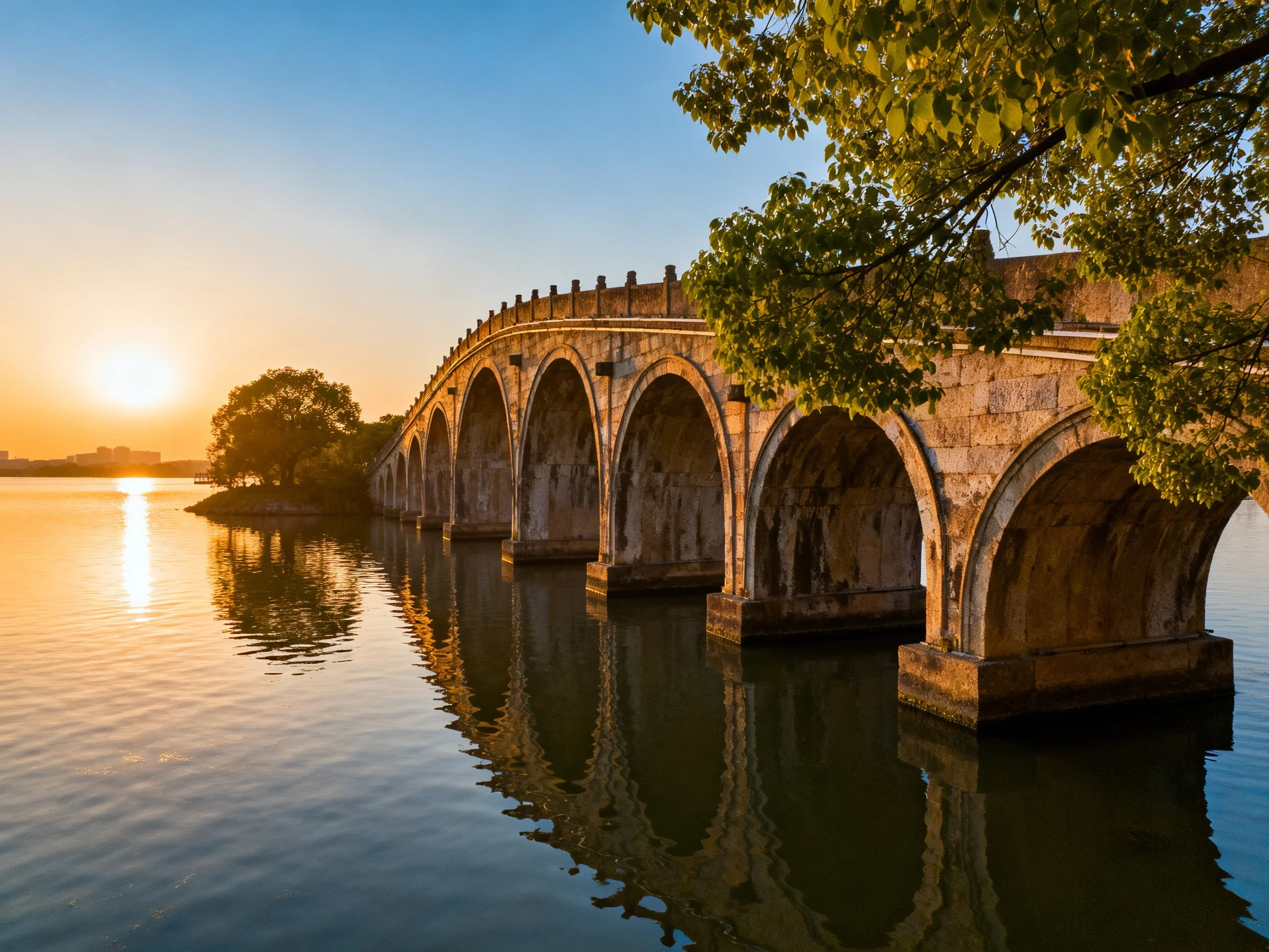 Ancient stone bridge spans calm waters at golden hour