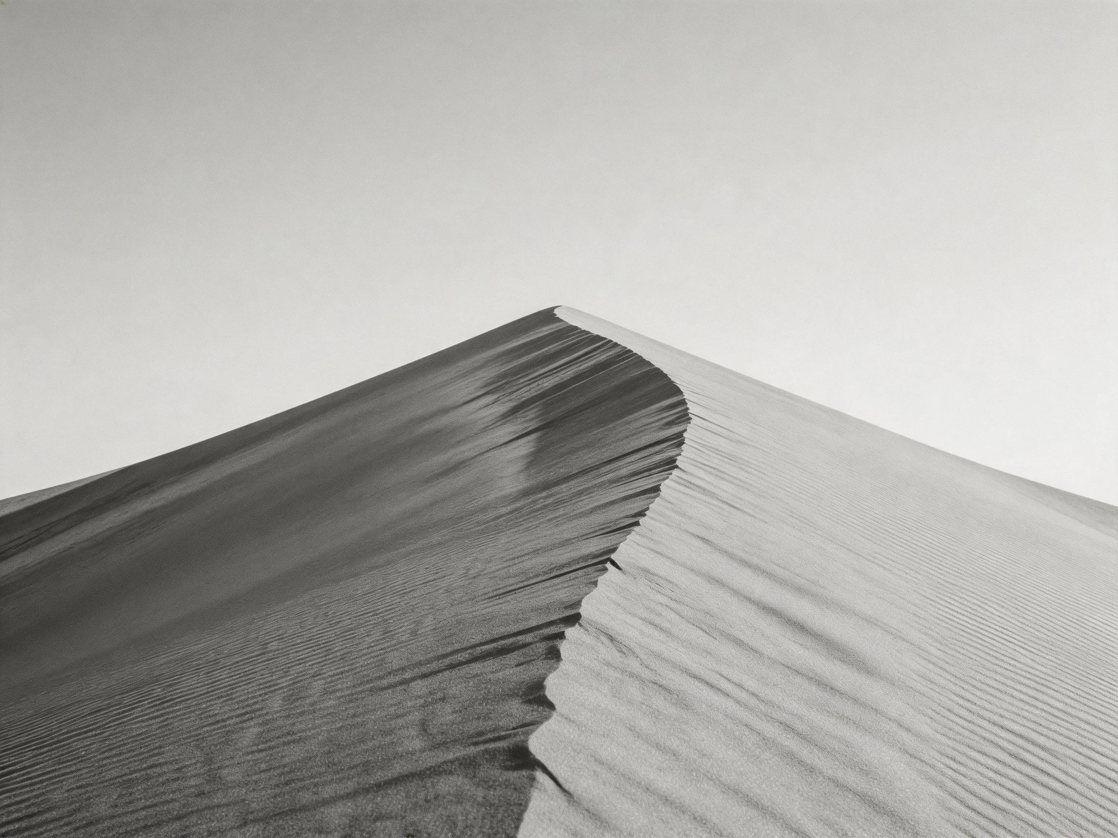 Black and white sand dune with curved ridge and textured patterns