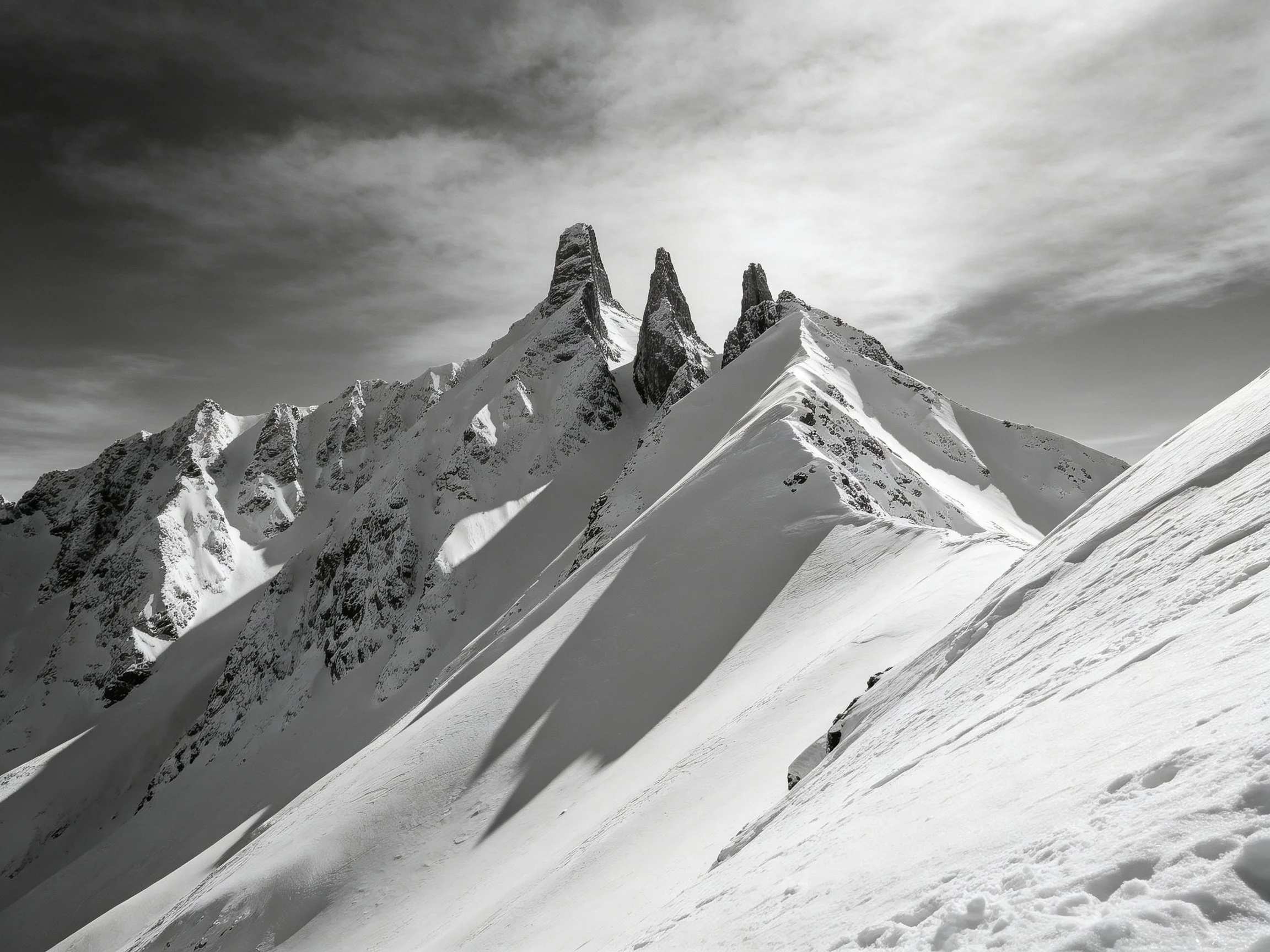 Black and white snow-covered mountain peaks with sharp summits