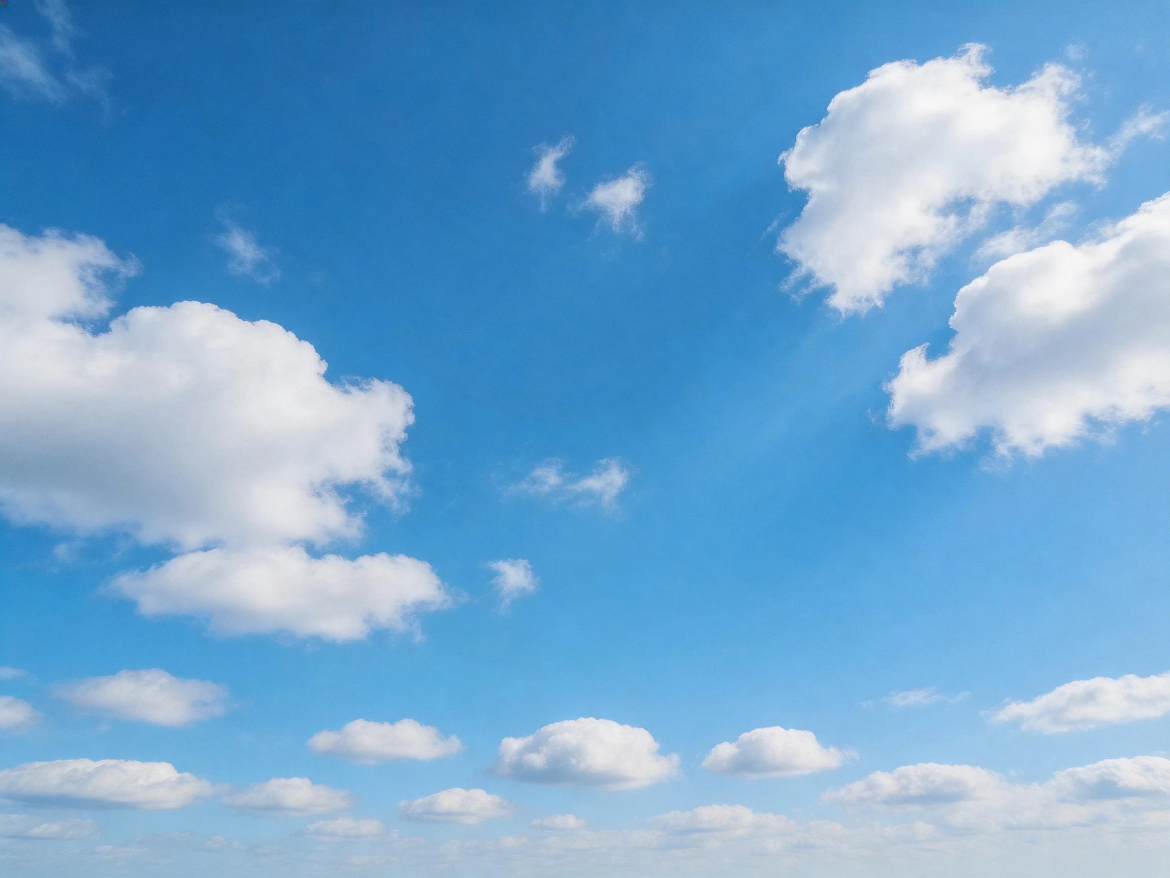 Bright blue sky with scattered fluffy white clouds