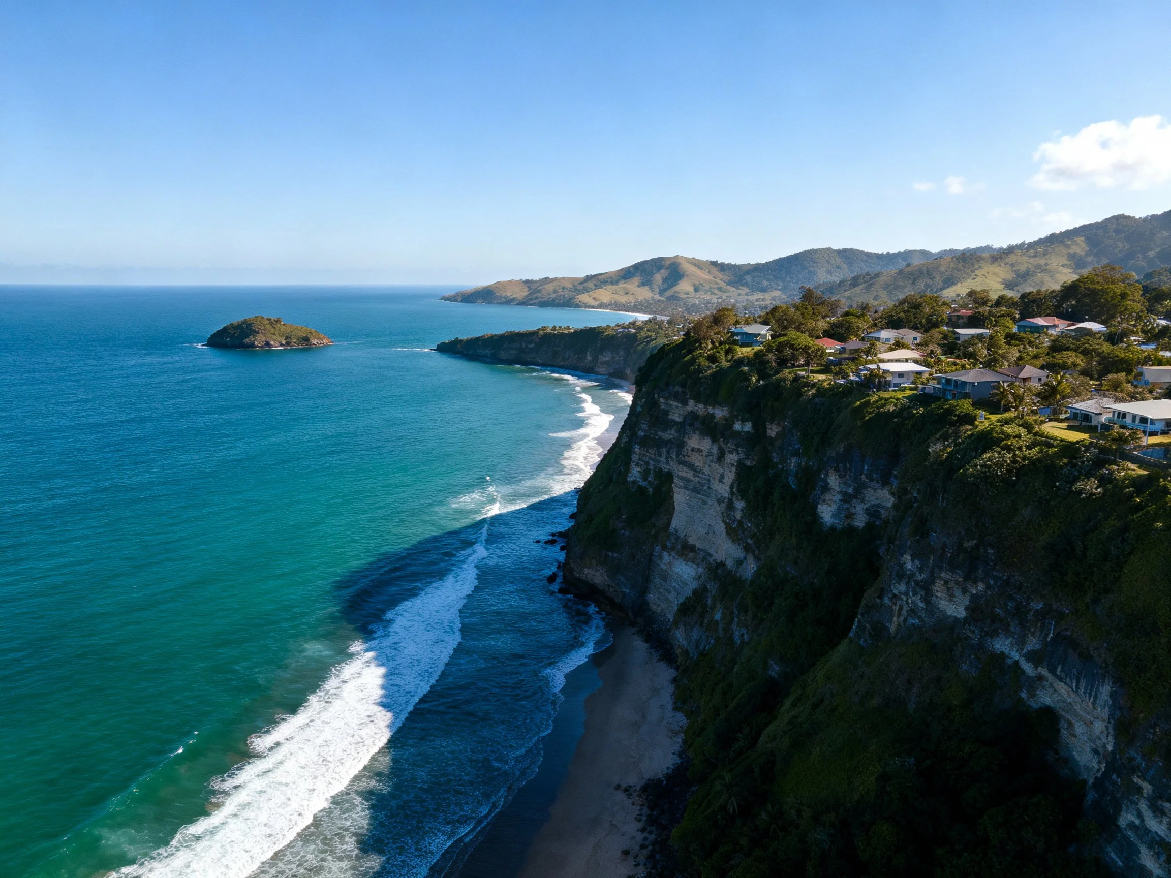 Coastal cliffs with turquoise waters and residential area