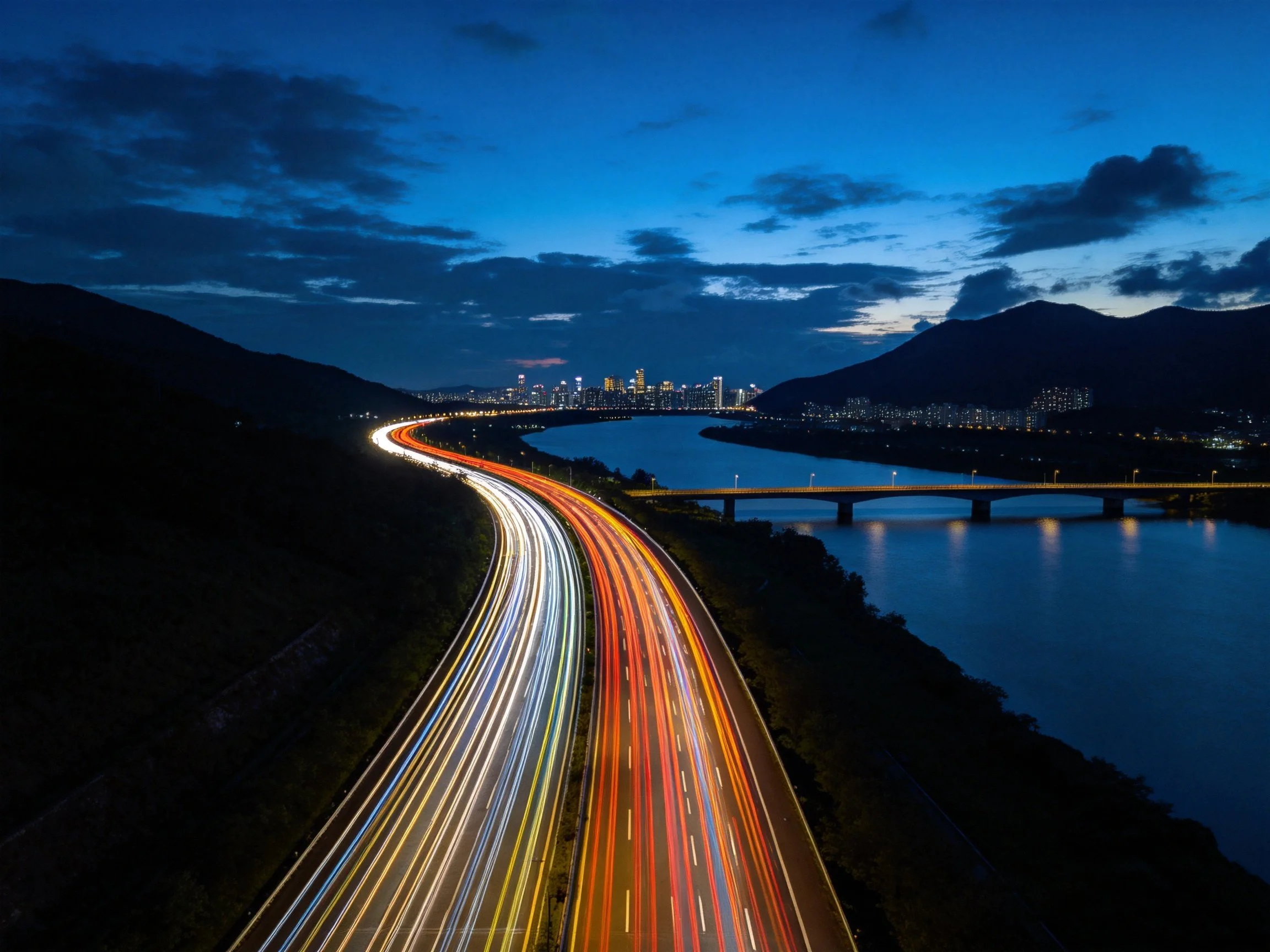 Colorful Light Trails Along Curved Highway at Night