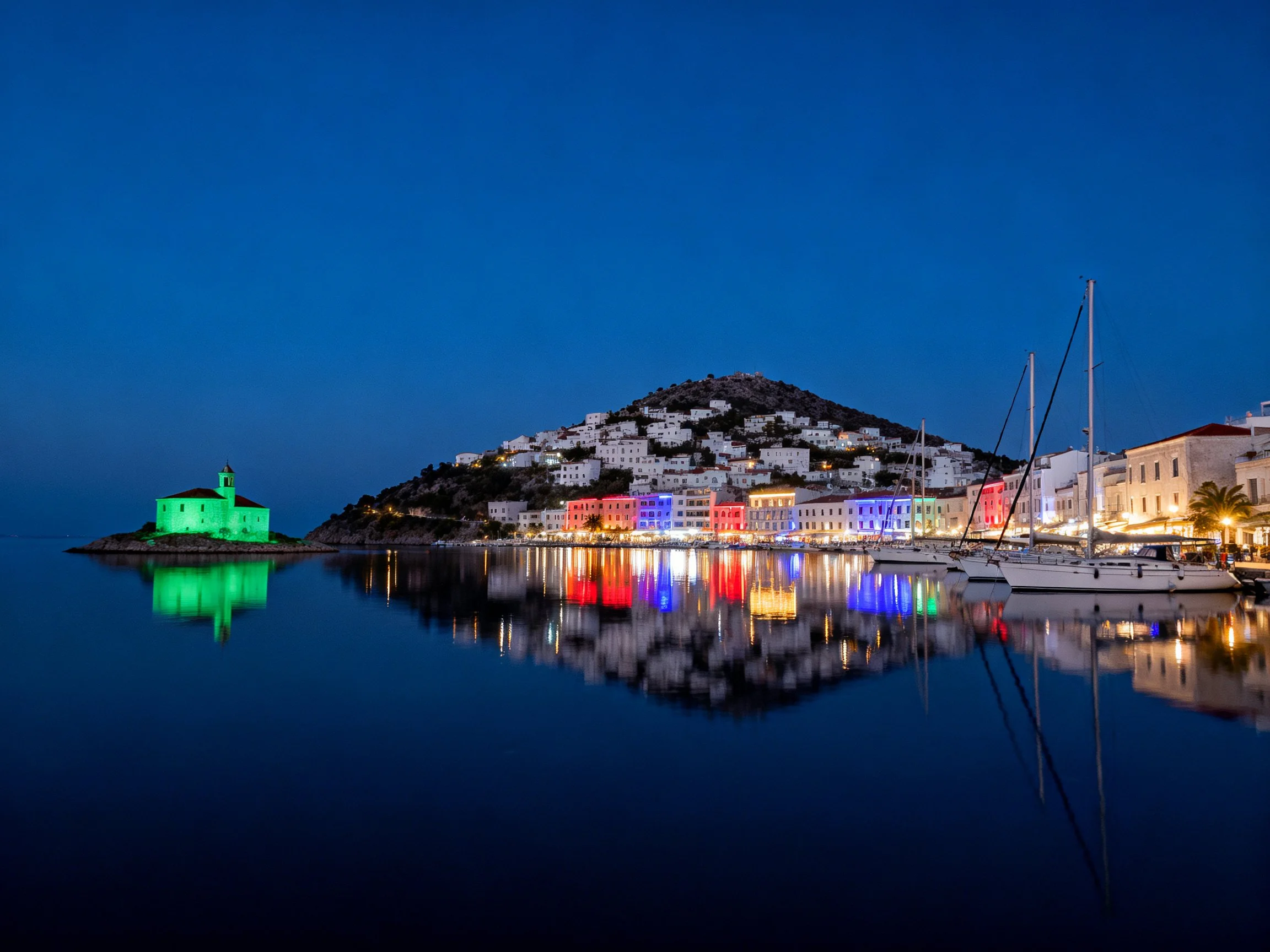 Colorful coastal village with illuminated buildings reflecting in calm waters