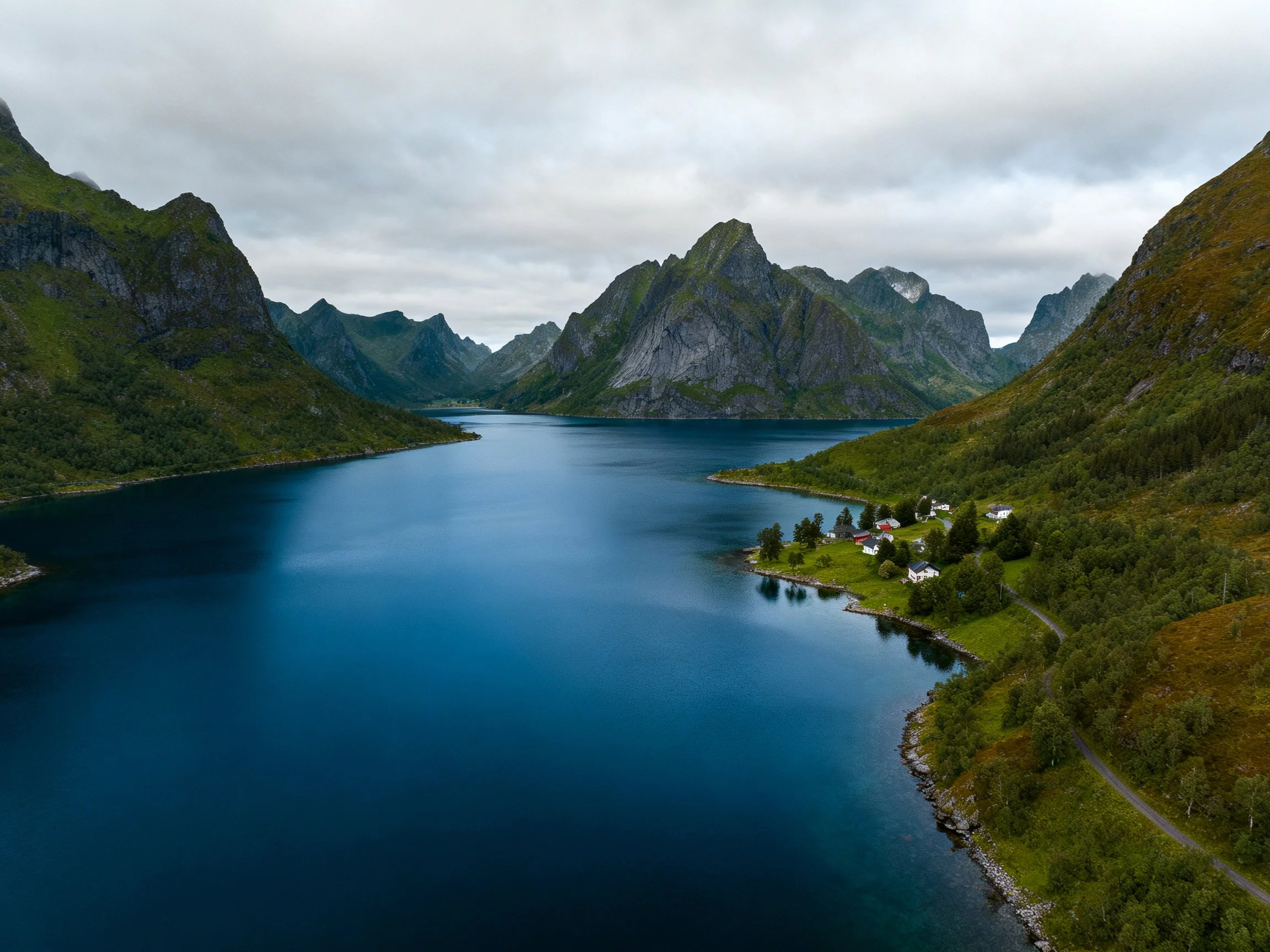 Deep blue fjord surrounded by lush green mountain landscapes