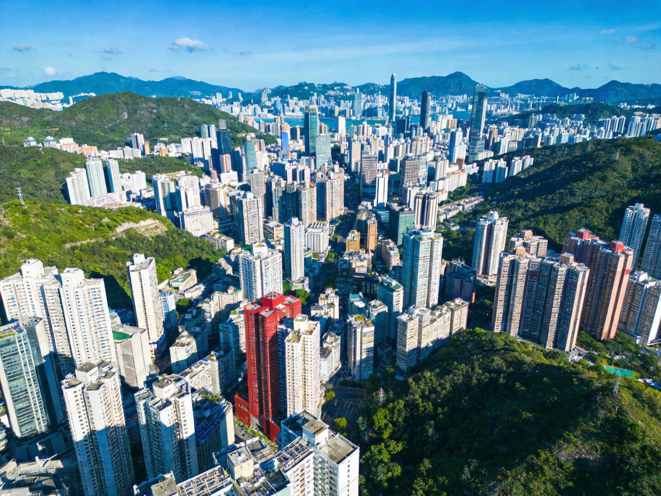 Dense urban skyline with high-rises and green mountain backdrop
