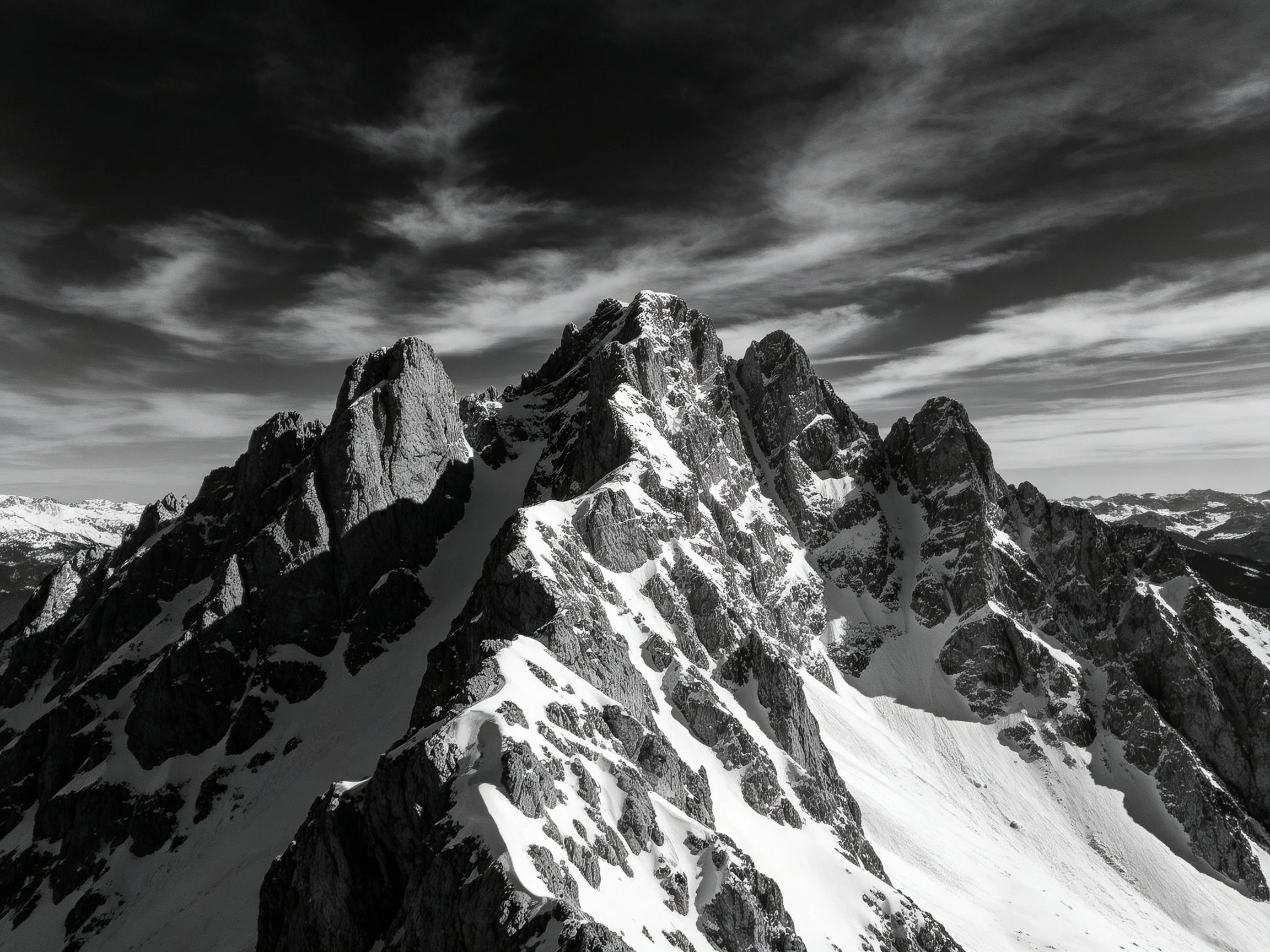 Dramatic Black-and-White Snow-Capped Mountain Peaks Under Stormy Sky