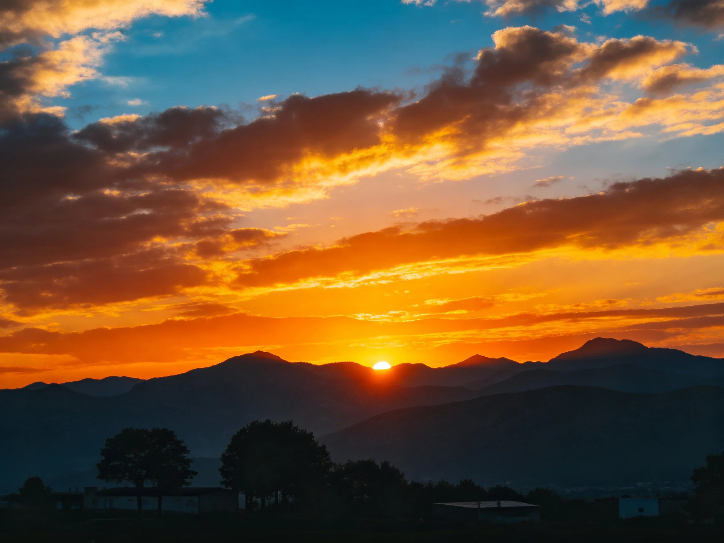 Dramatic Sunset Over Mountain Range With Golden Clouds