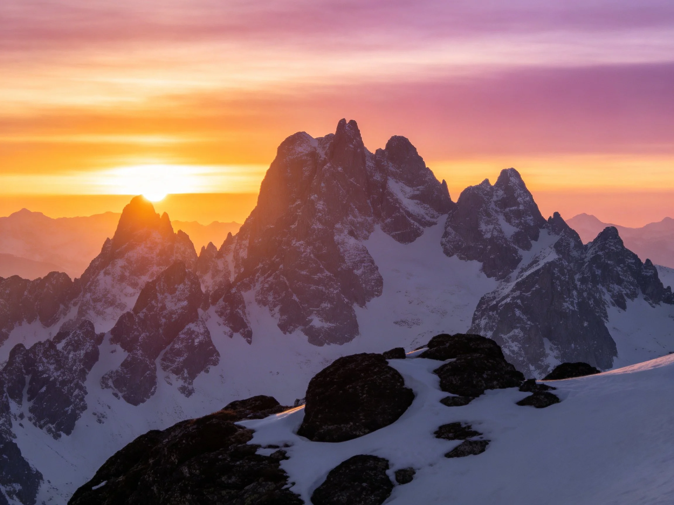 Dramatic snow-capped mountain peaks at dawn with colorful twilight sky