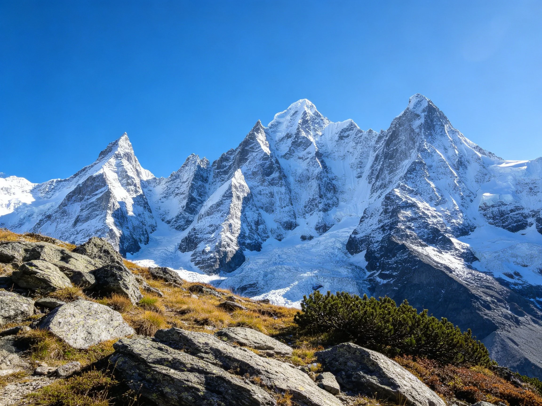 Dramatic snow-capped mountain peaks with rugged rocky foreground terrain