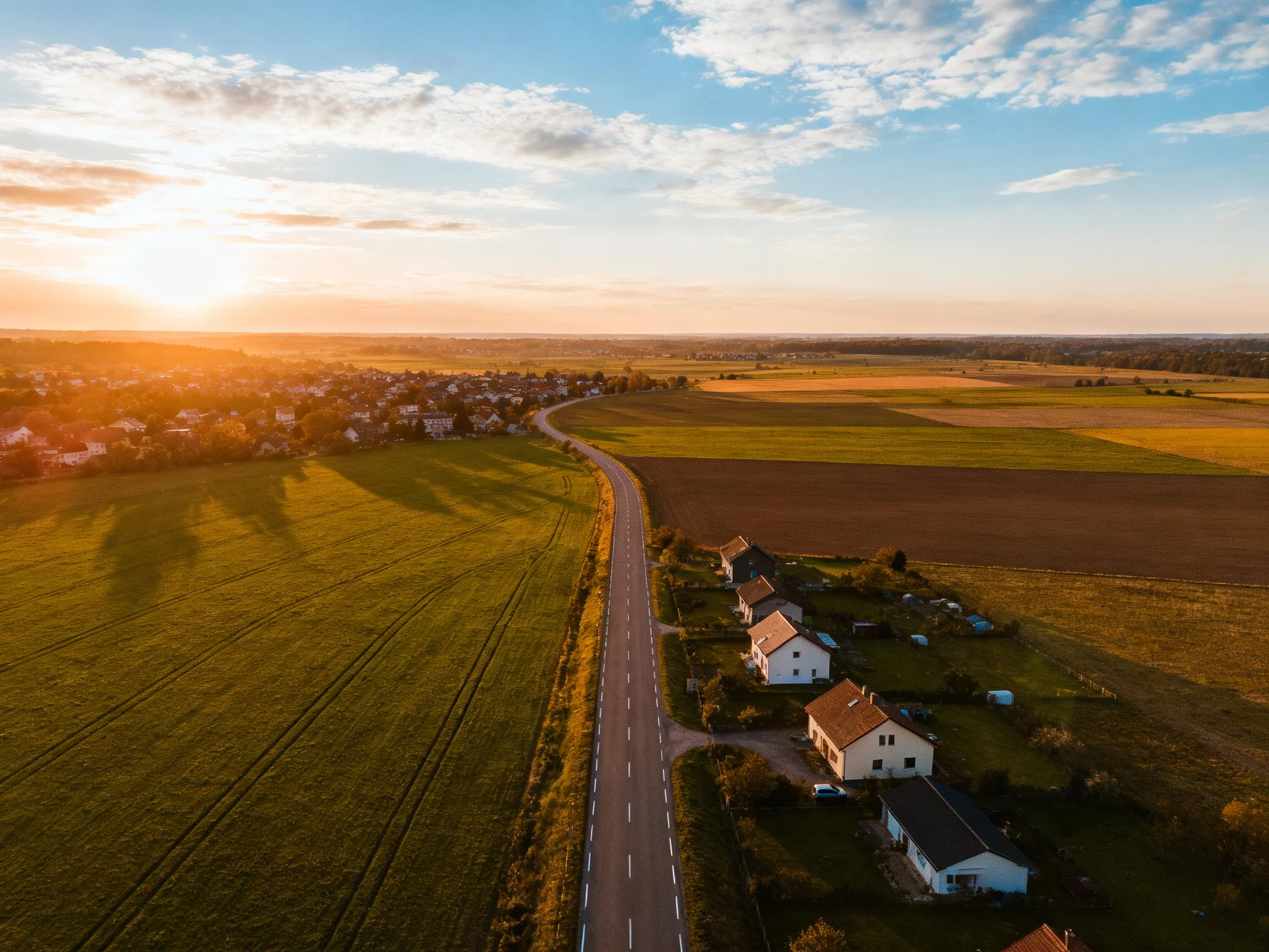 Golden Sunset Lights Rural Road and Farmhouses