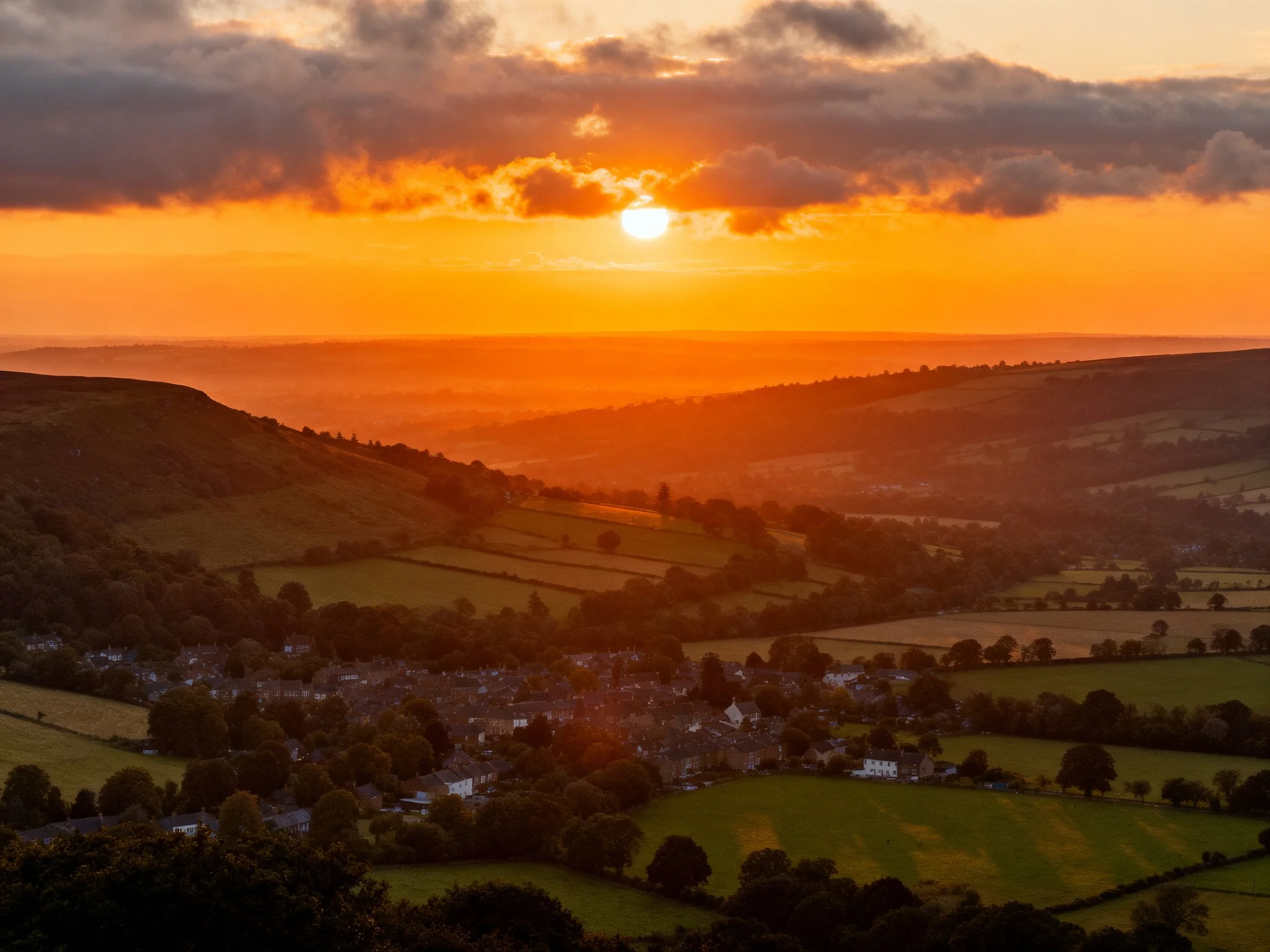 Golden Sunset Over Rolling Hills and Rural Village