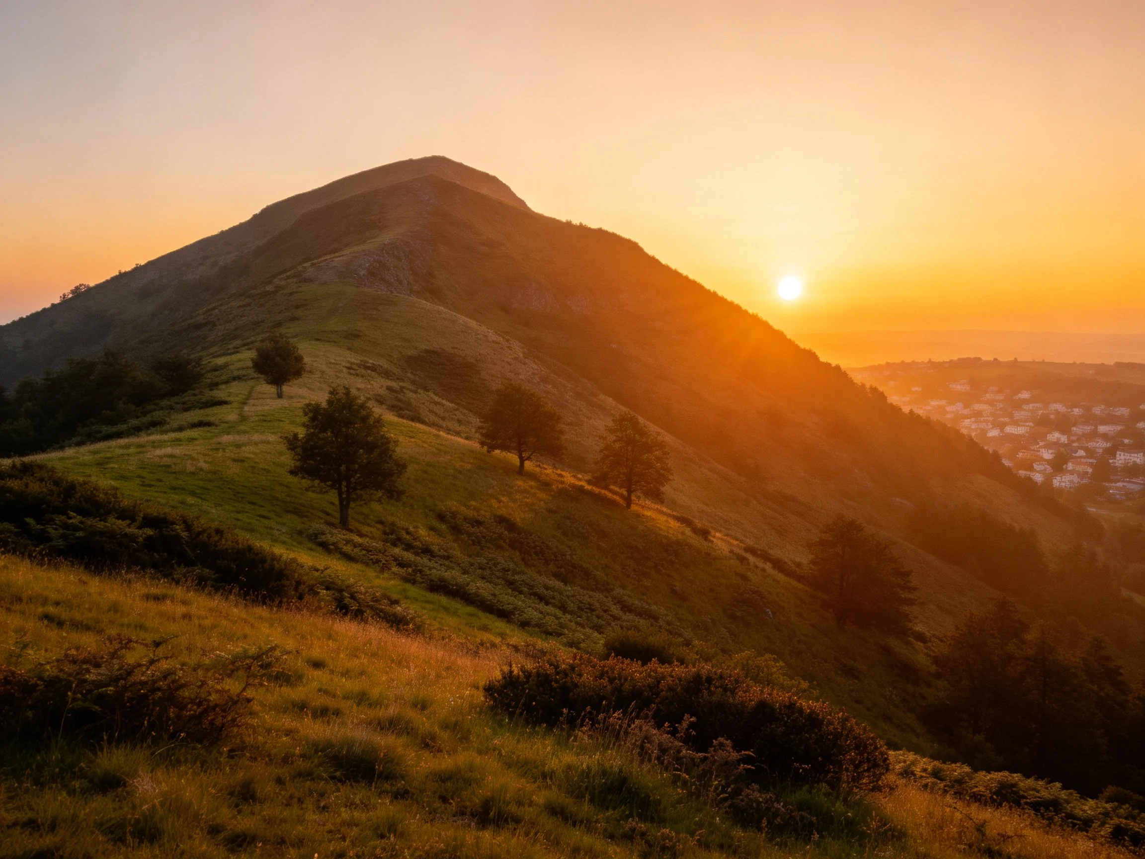 Golden Sunset Over Rolling Mountain Slopes With Scattered Trees