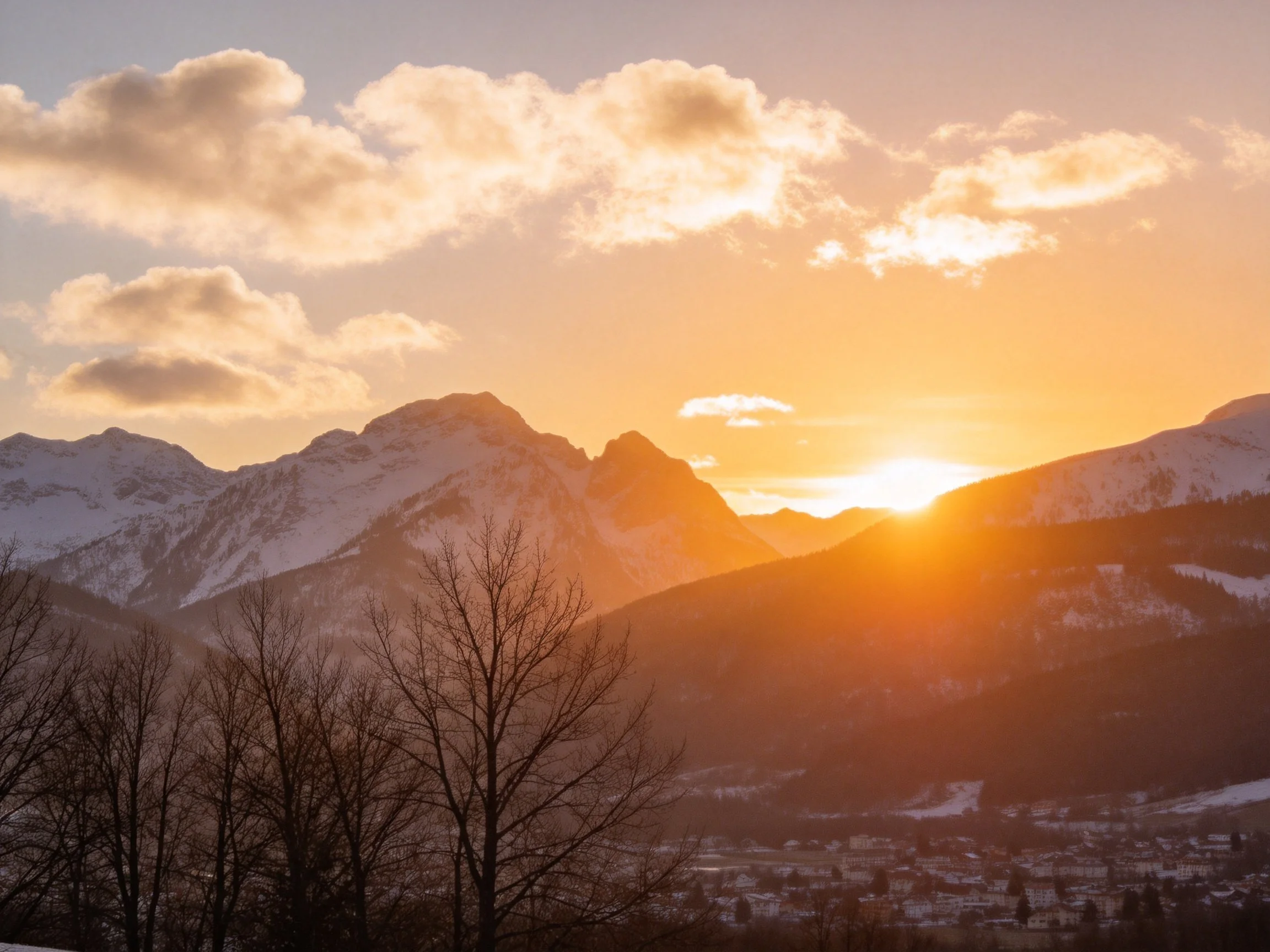 Golden Sunset Over Snow-Capped Mountain Peaks and Forested Valley