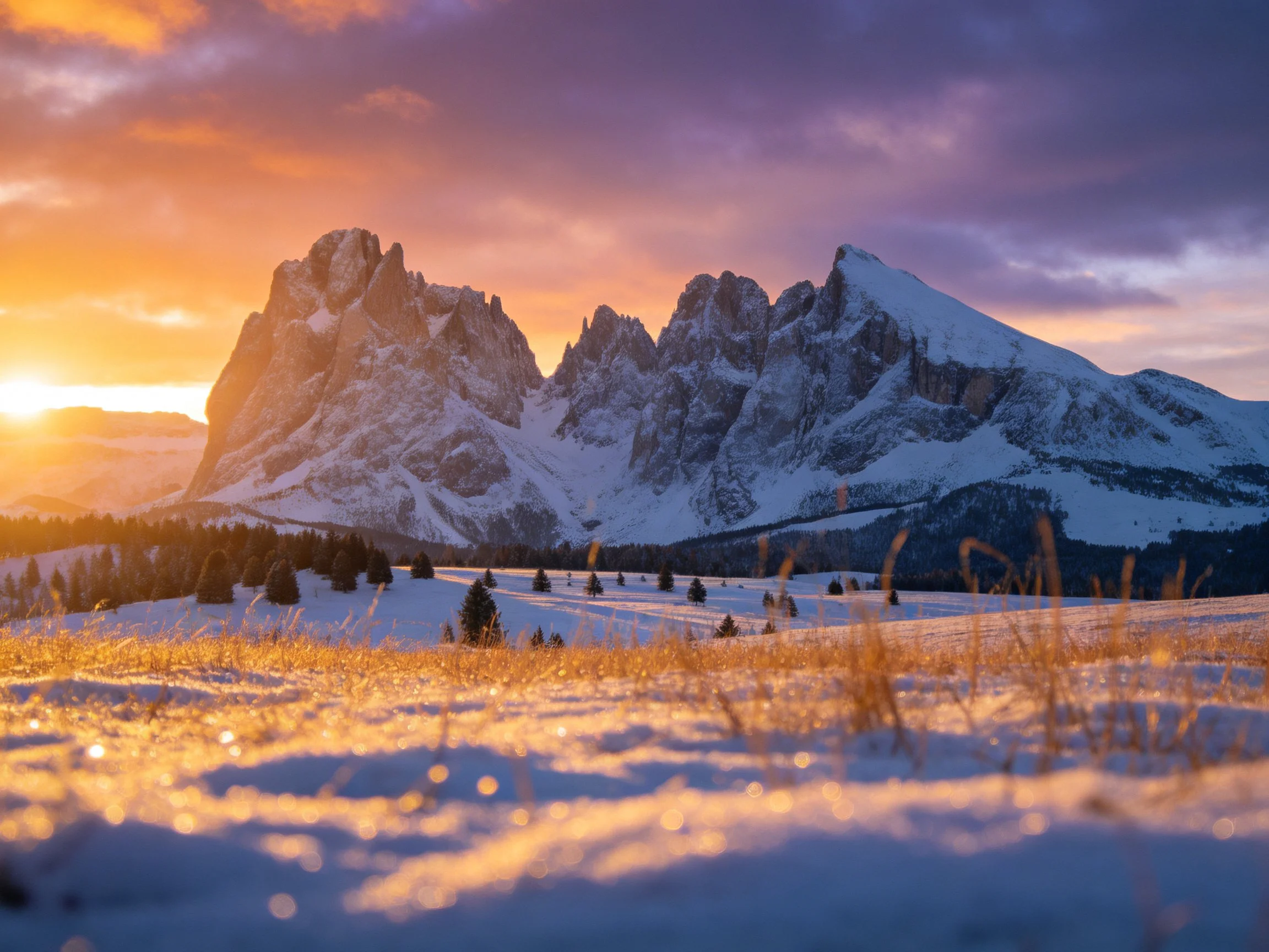 Golden-hued sunset over snow-draped mountain peaks