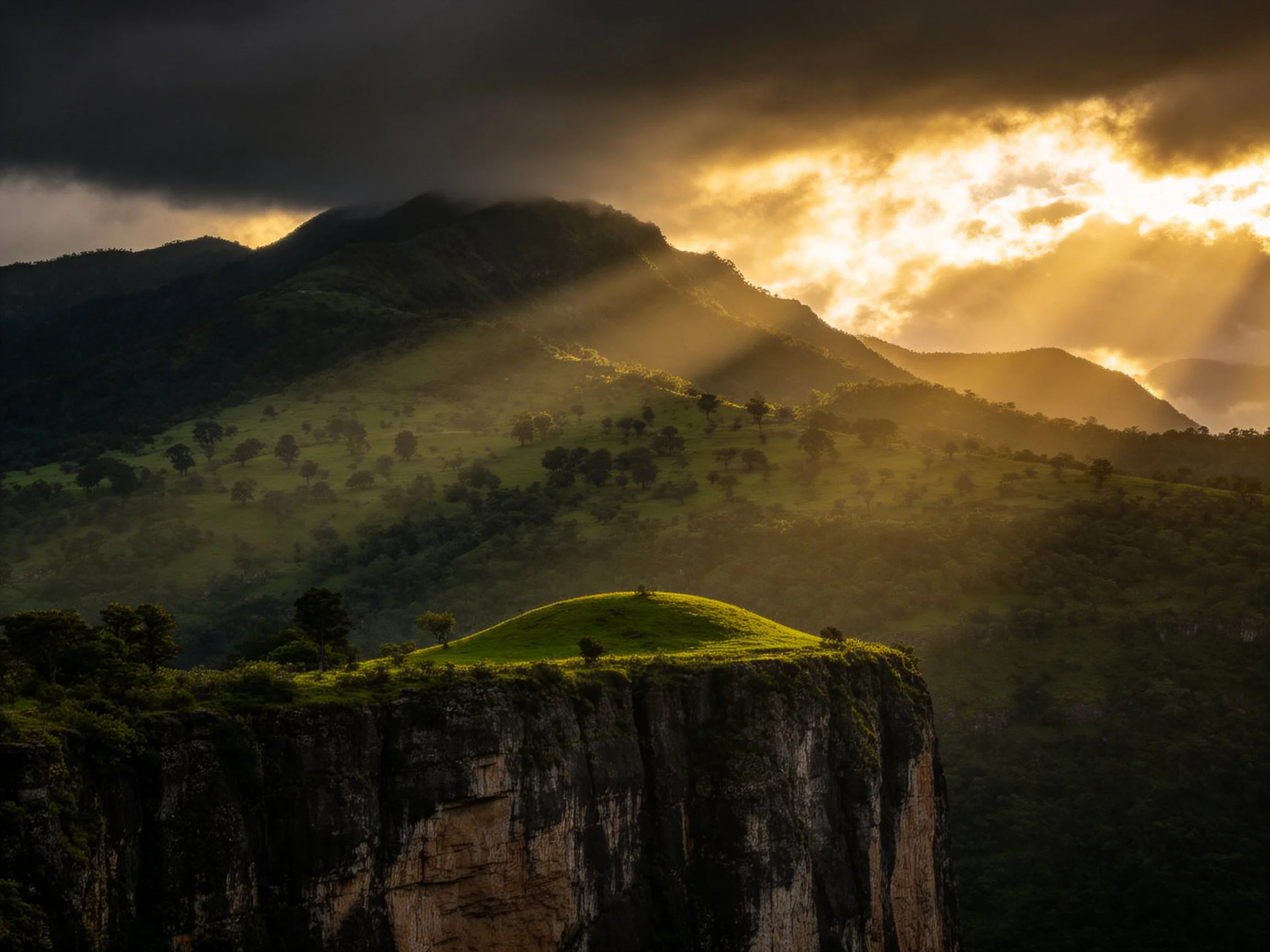 Golden sunbeams pierce clouds over lush green mountain cliffs