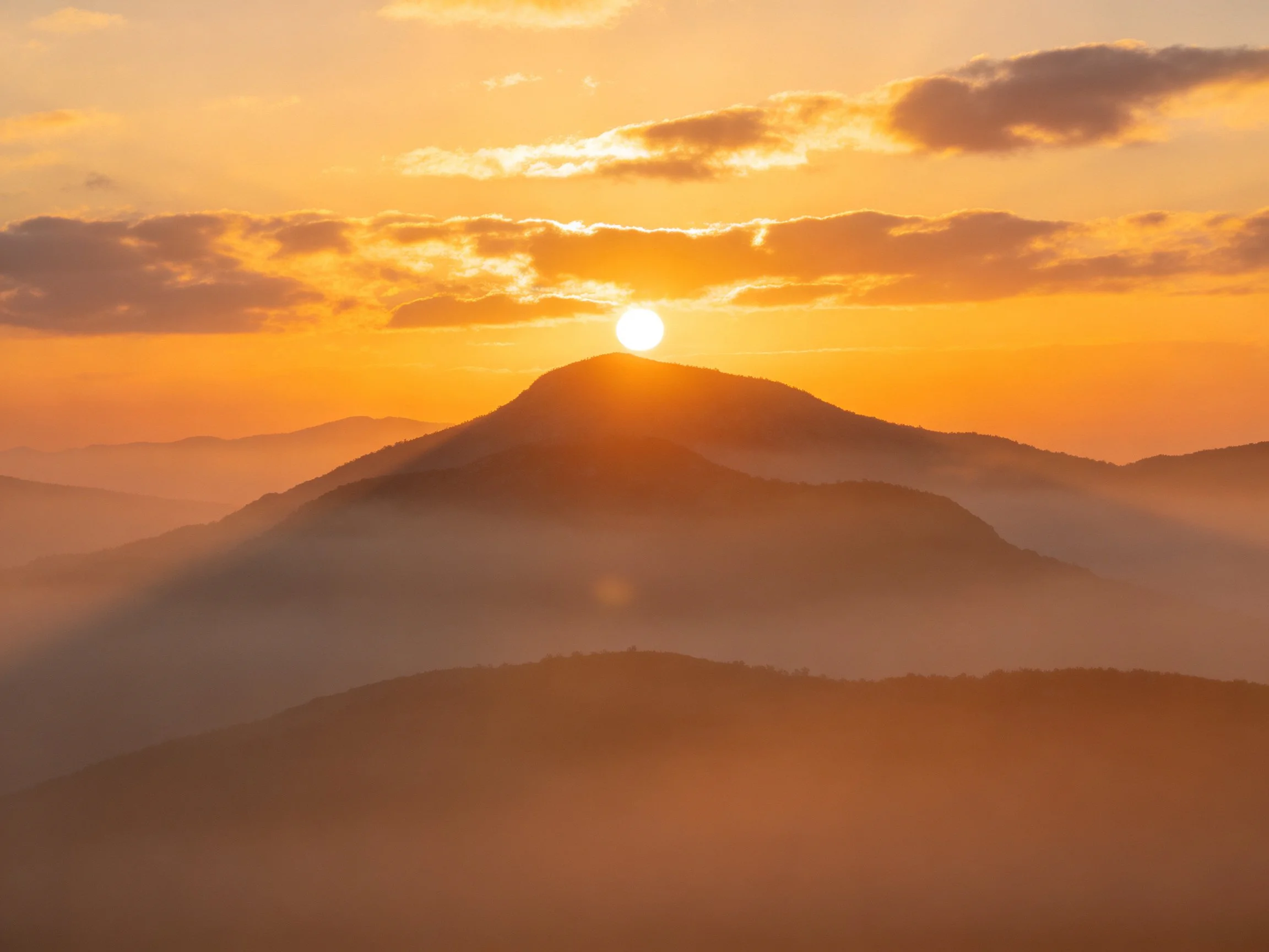 Golden sunrise over misty mountain peaks