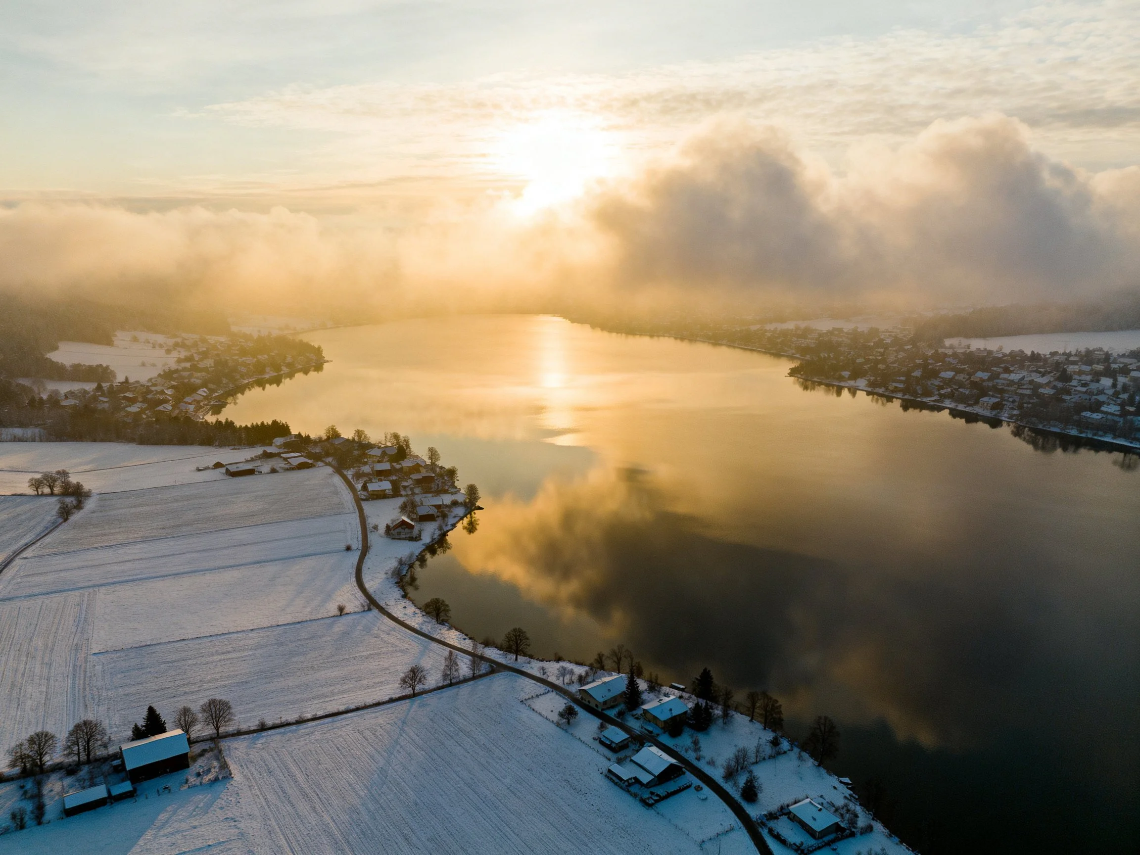 Golden sunrise over snow-draped fields and winding river