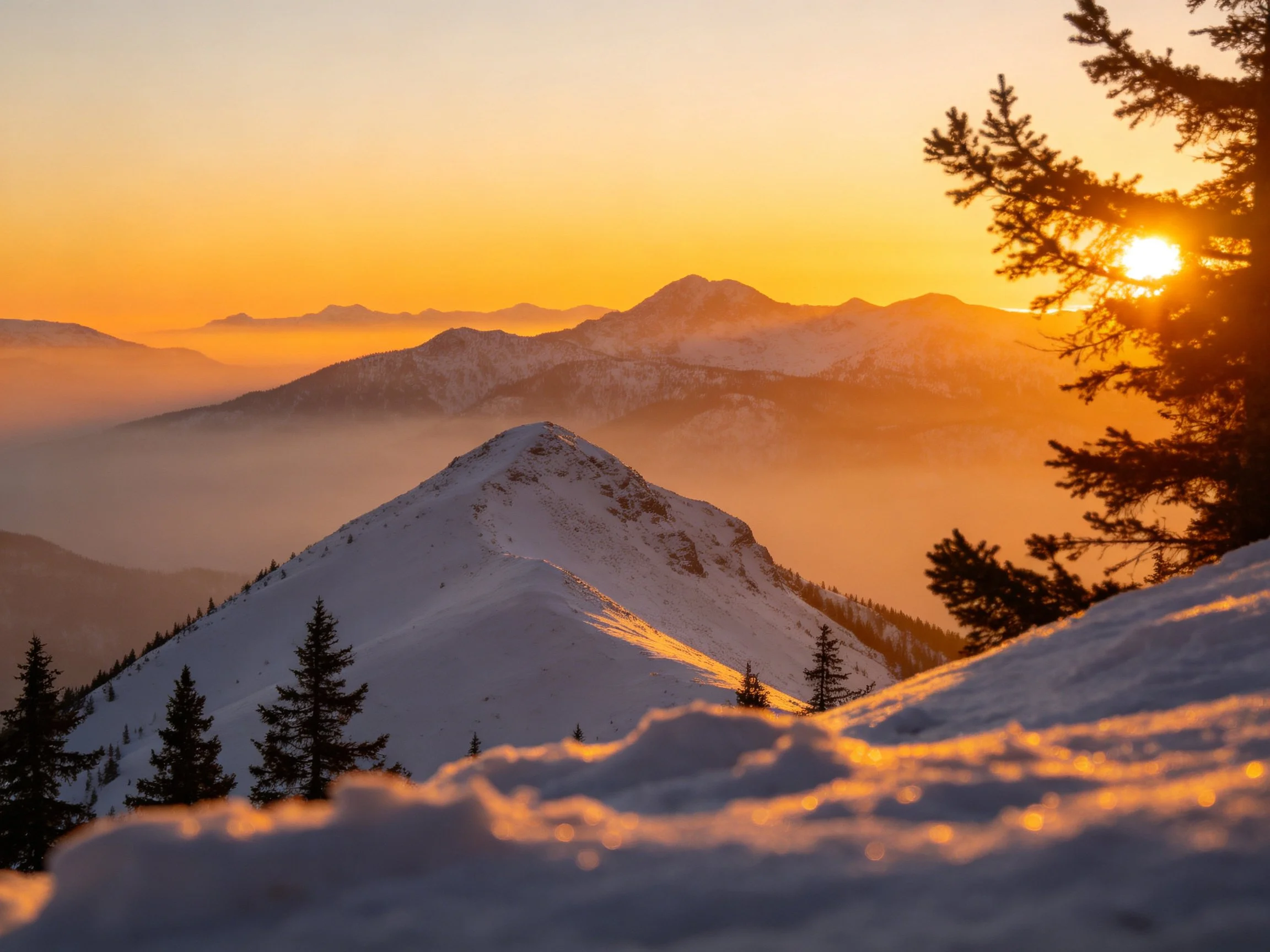 Golden sunset illuminates snow-covered mountain peaks