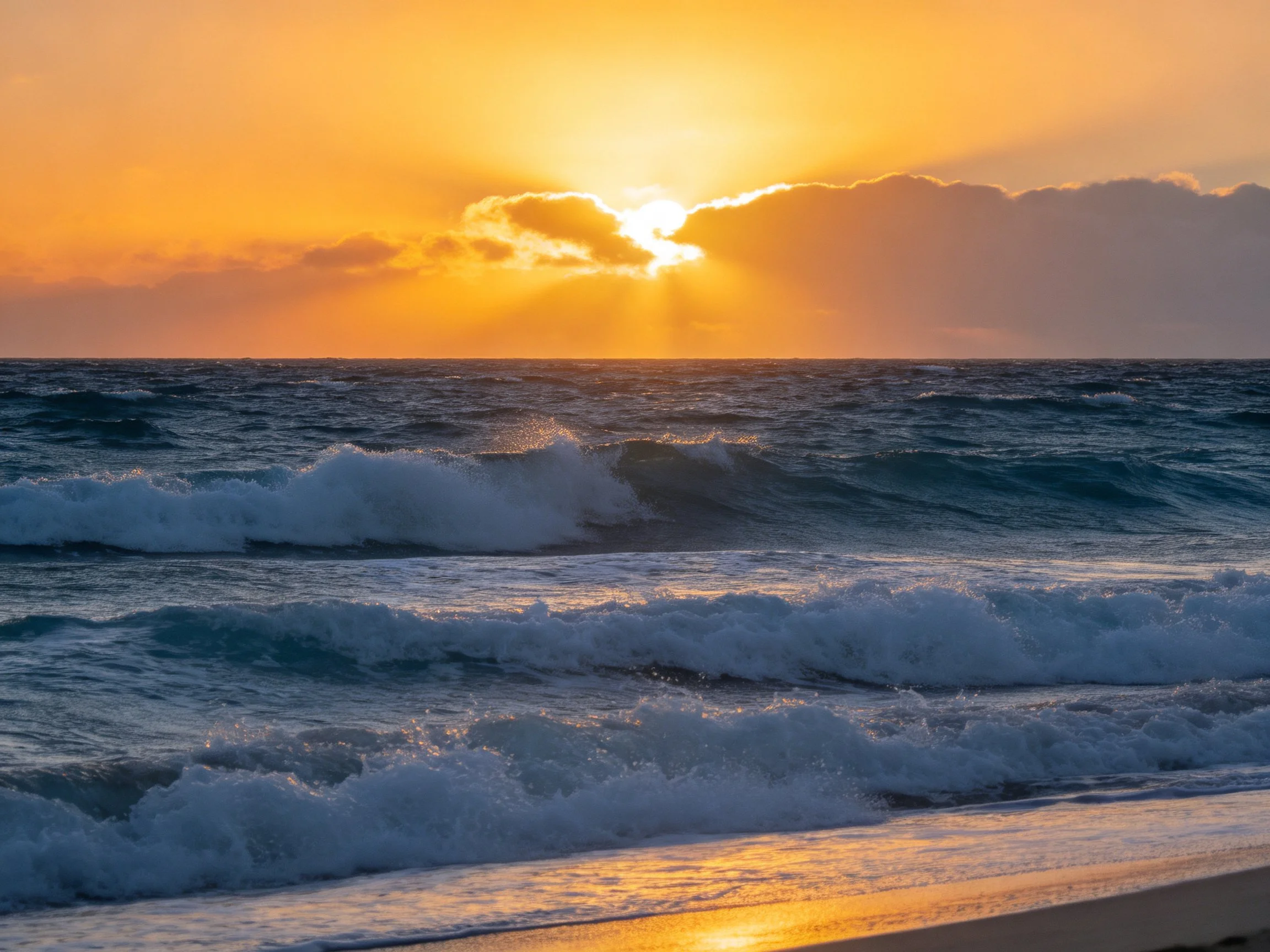 Golden sunset illuminates turquoise ocean waves