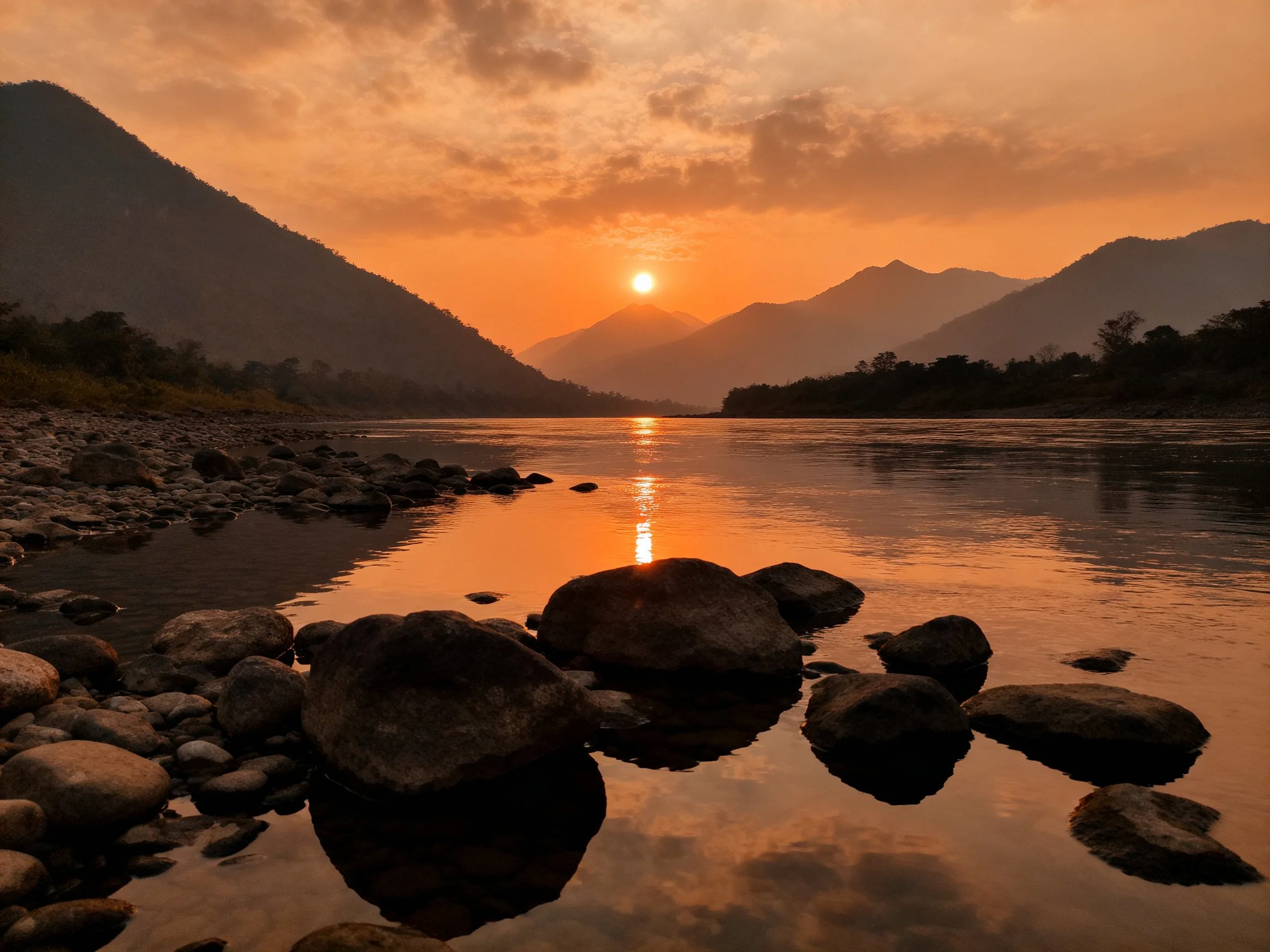 Golden sunset over mountain river with rocky shoreline