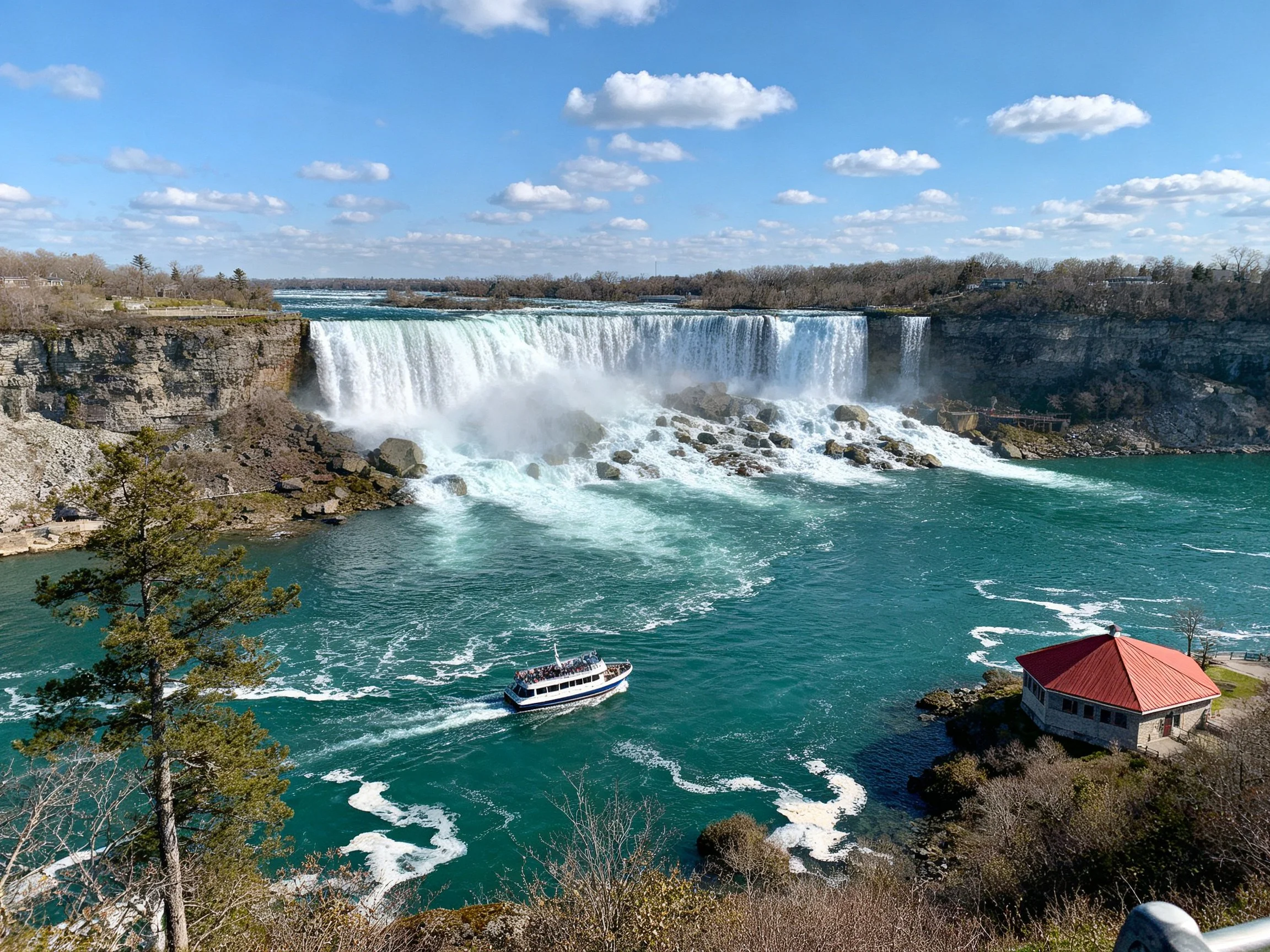 Grand waterfall with turquoise river, red-roofed building, and tour boat