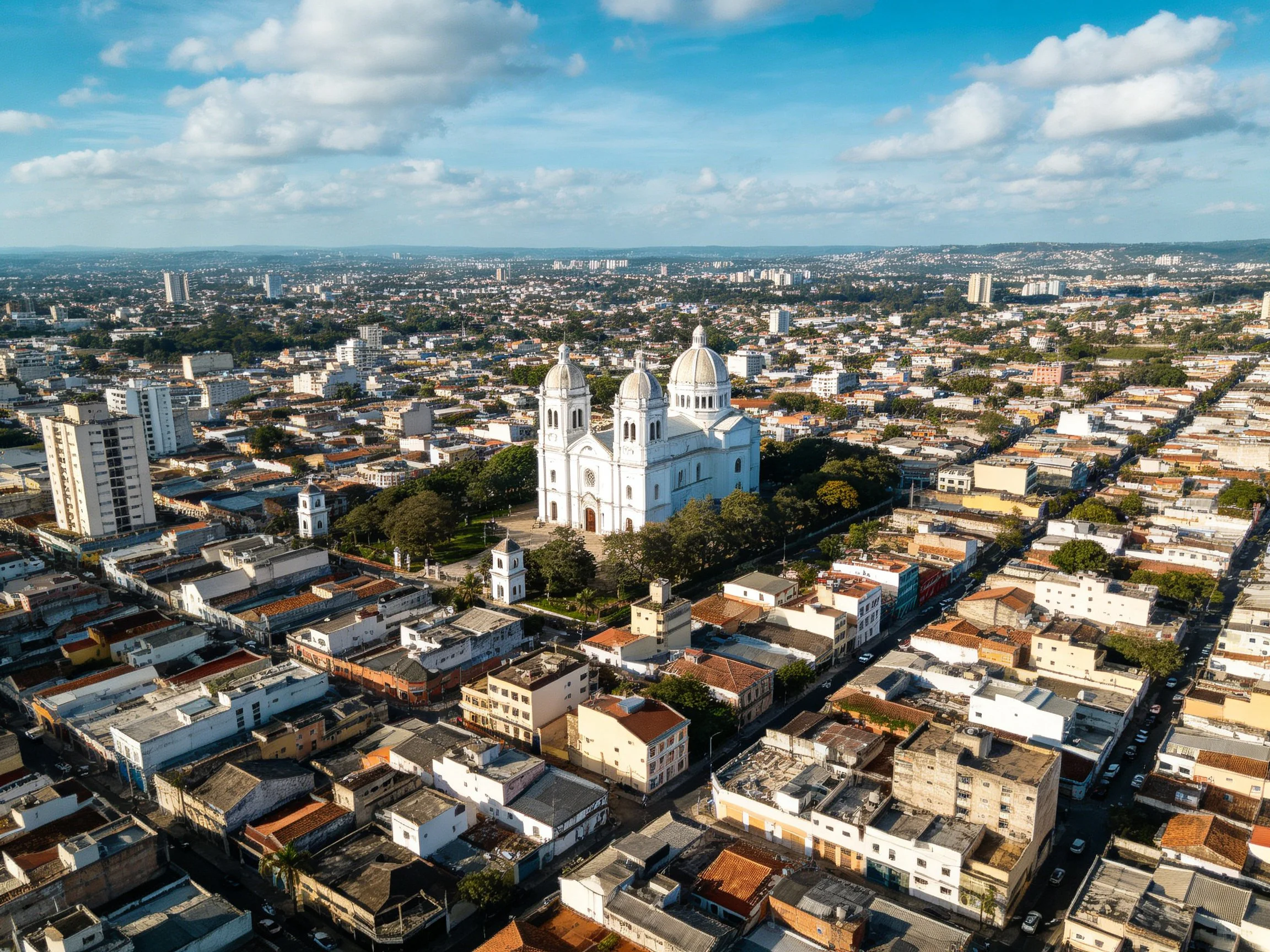 Large white cathedral with three domes dominates city center among diverse architecture