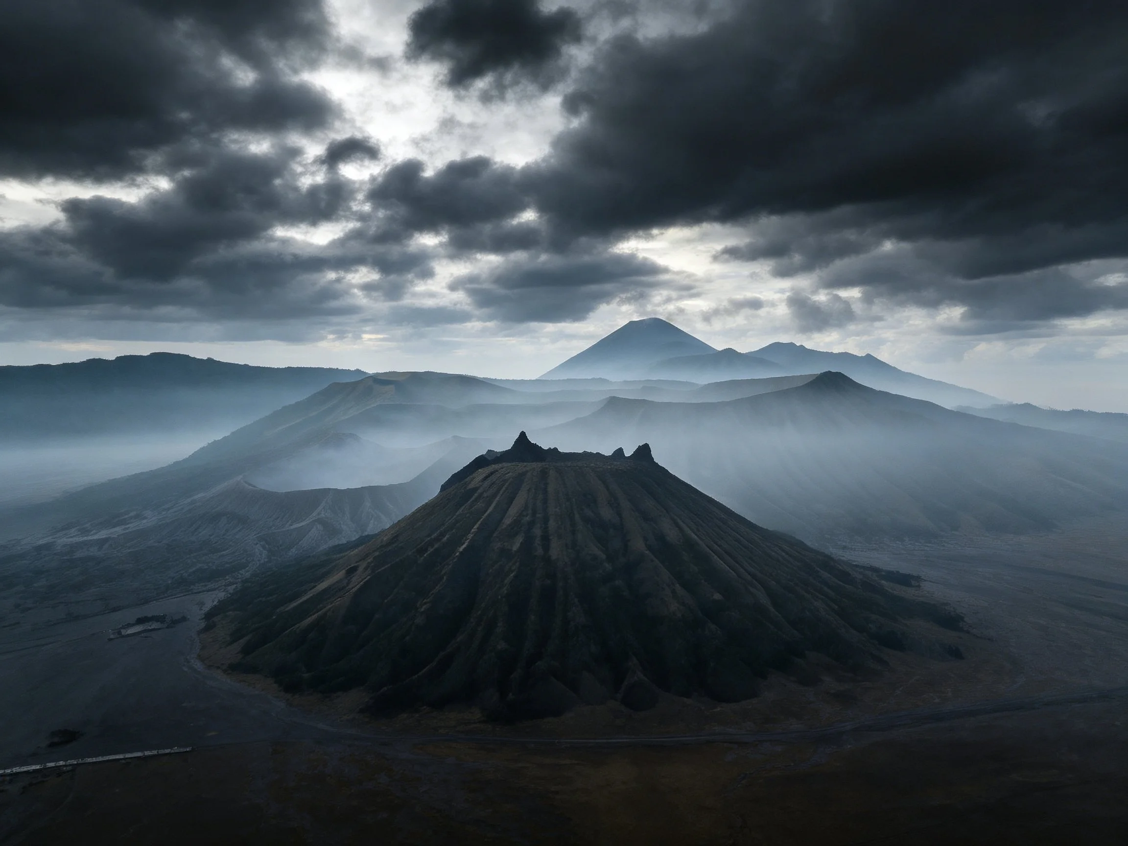 Majestic Volcano Under Stormy Skies with Misty Valleys