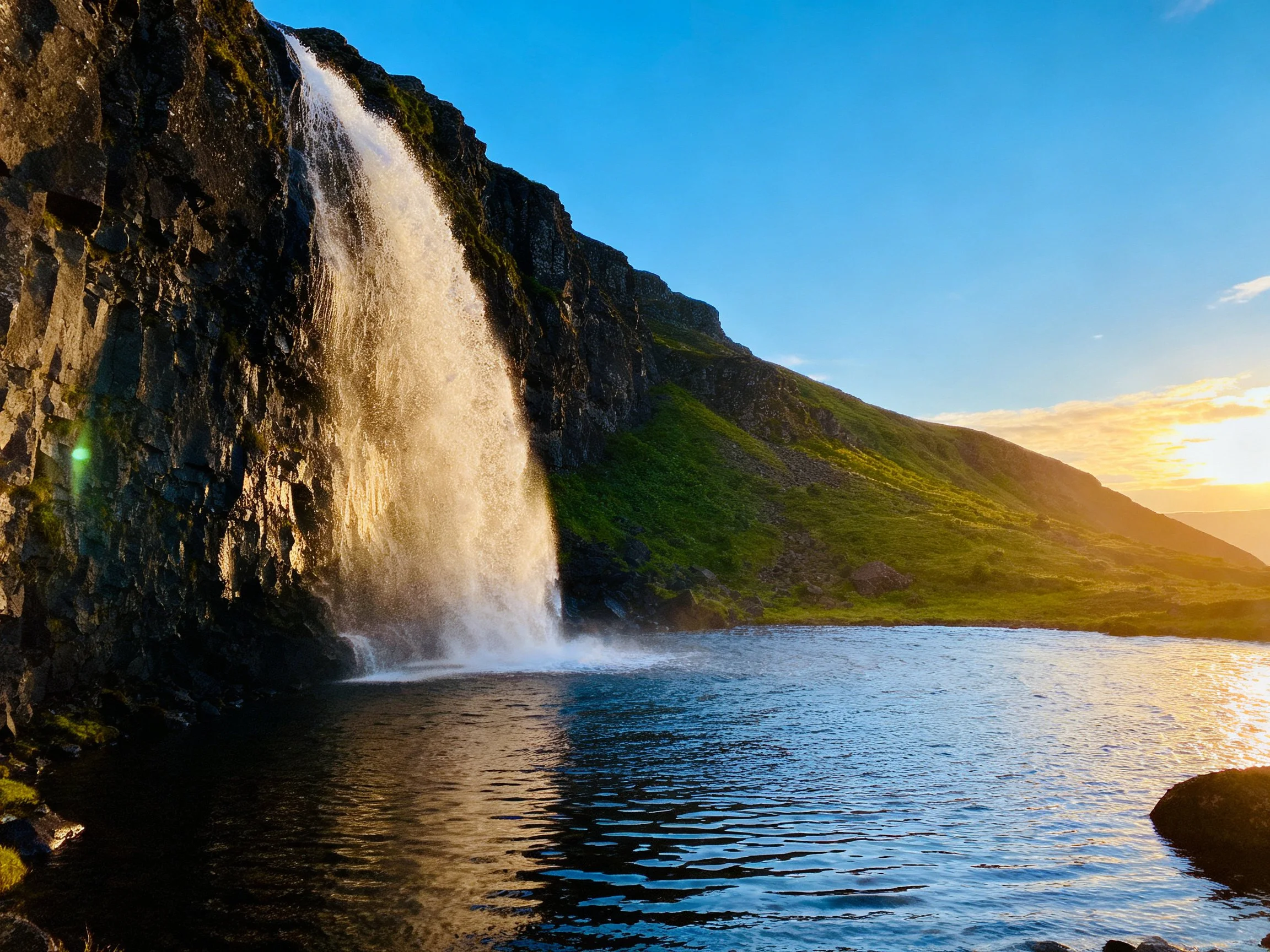 Majestic waterfall cascades over dark cliffs into a serene pool