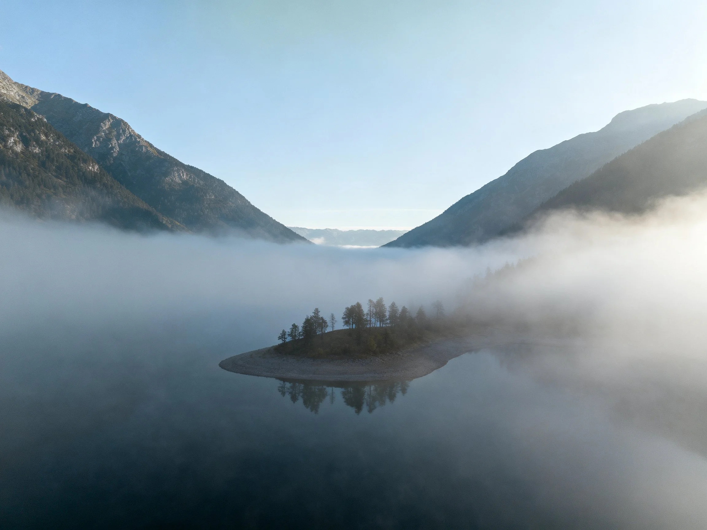 Misty Mountain Lake with Tree-Covered Island and Foggy Valleys
