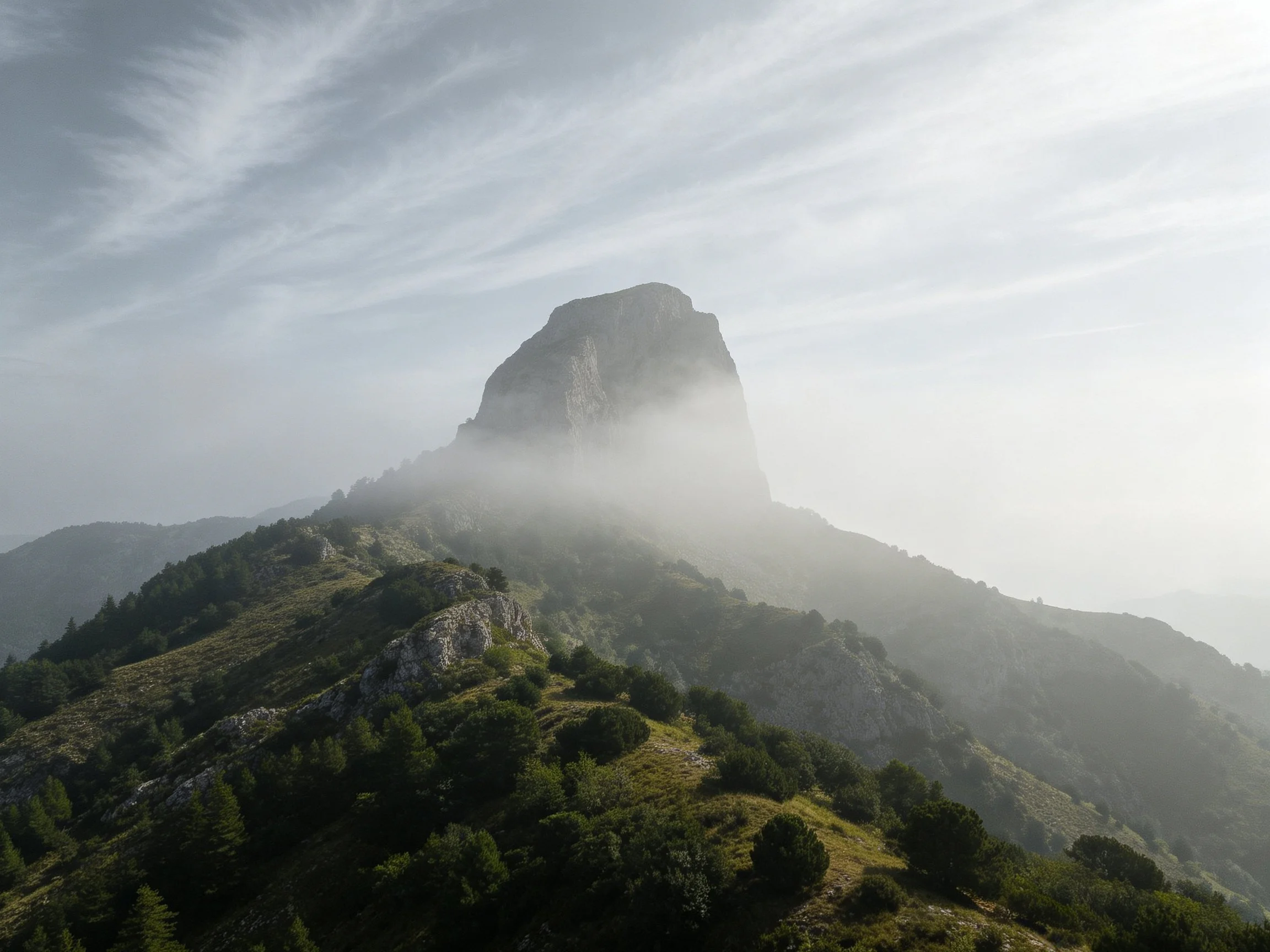 Misty Mountain Peak Rising Above Lush Green Terrain