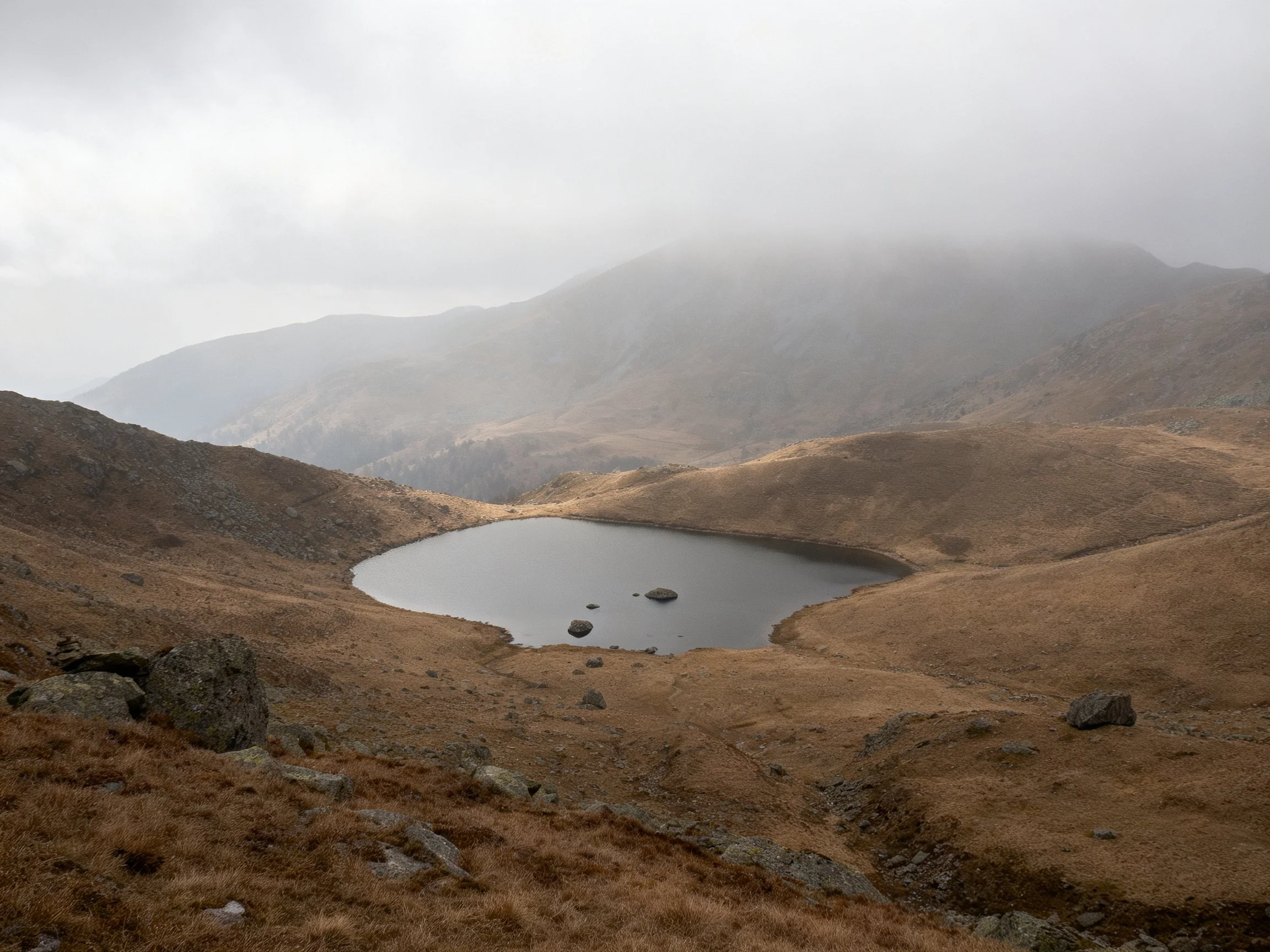 Misty Mountain Valley with a Small Lake and Earth-Toned Terrain