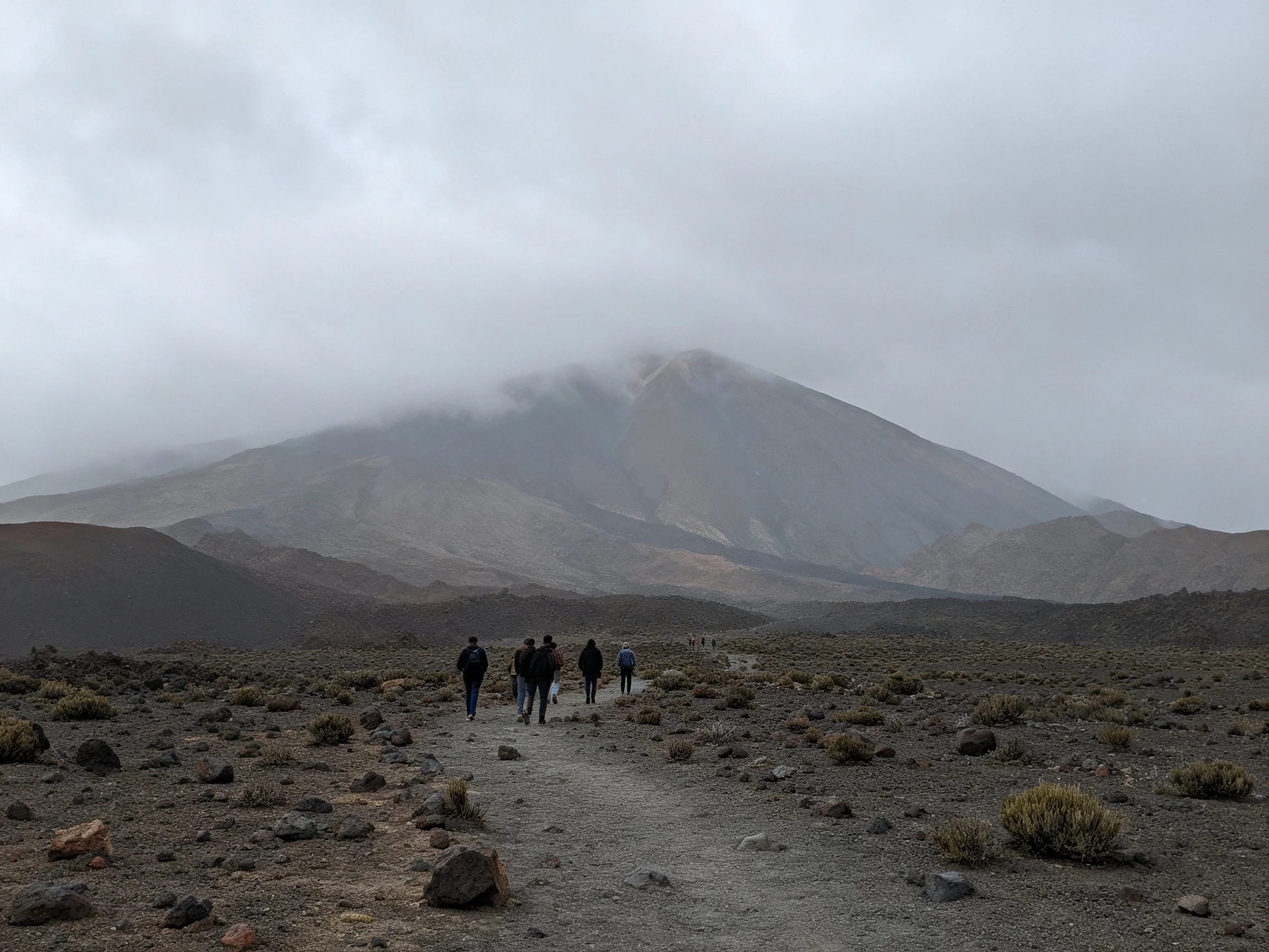 Misty mountain landscape with hikers on a rocky trail
